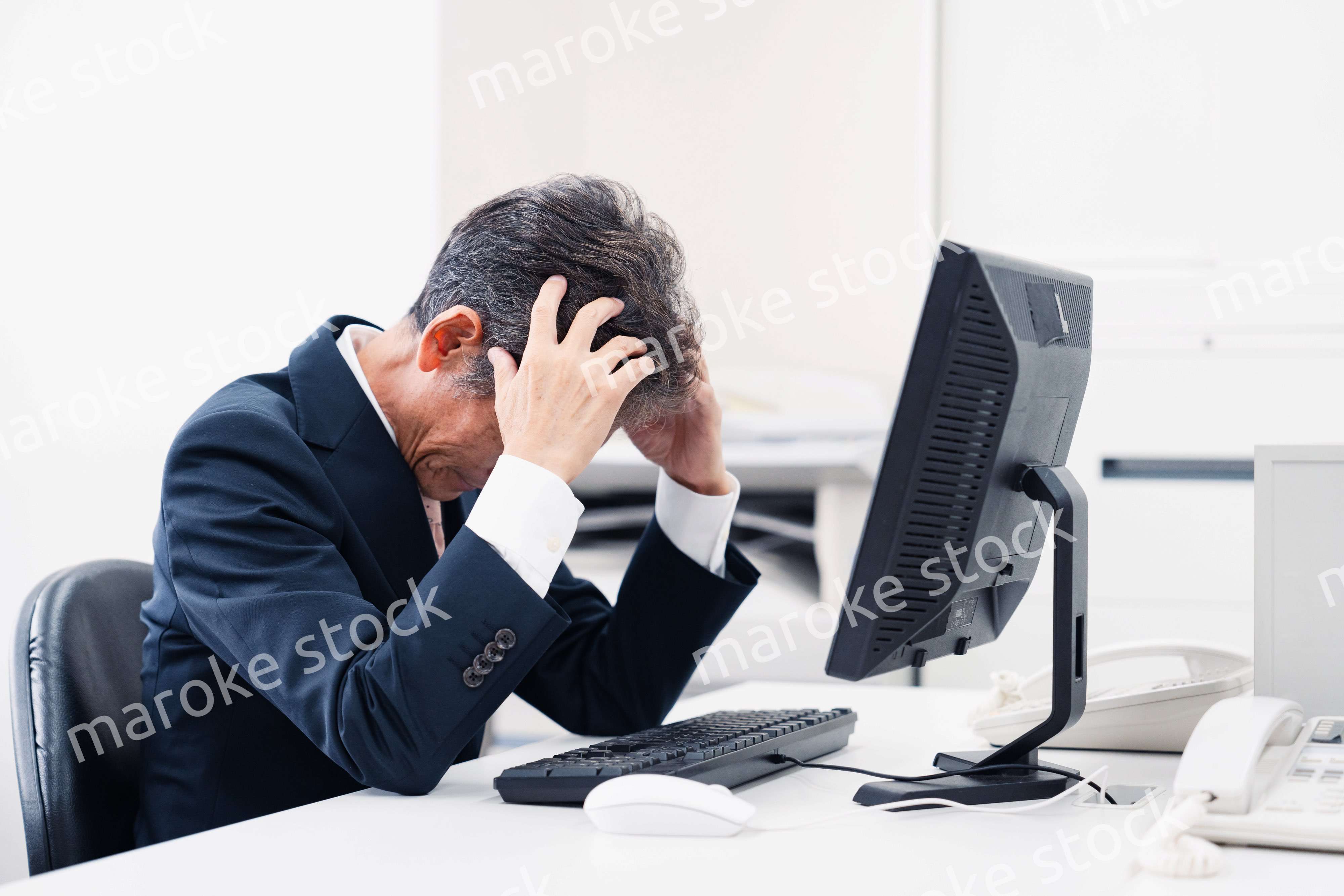 頭を抱えるミドルマネジメントの男性