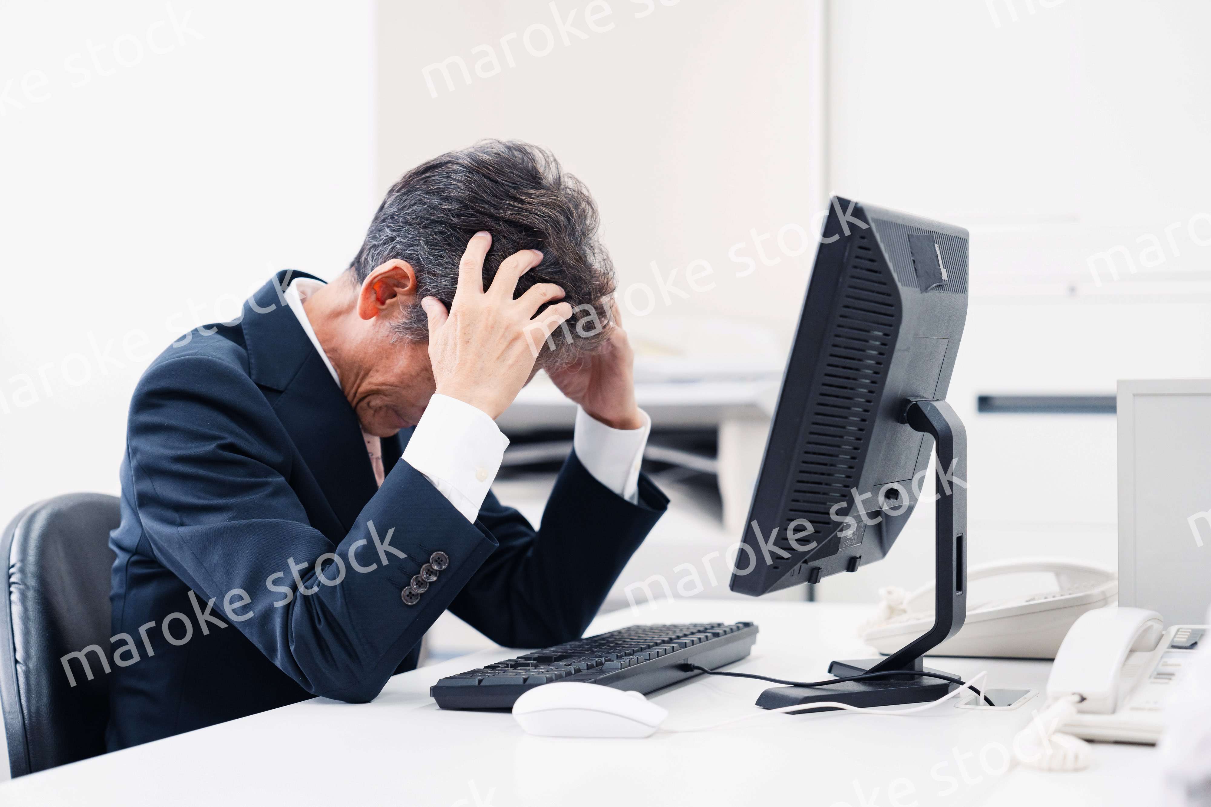 頭を抱えるミドルマネジメントの男性