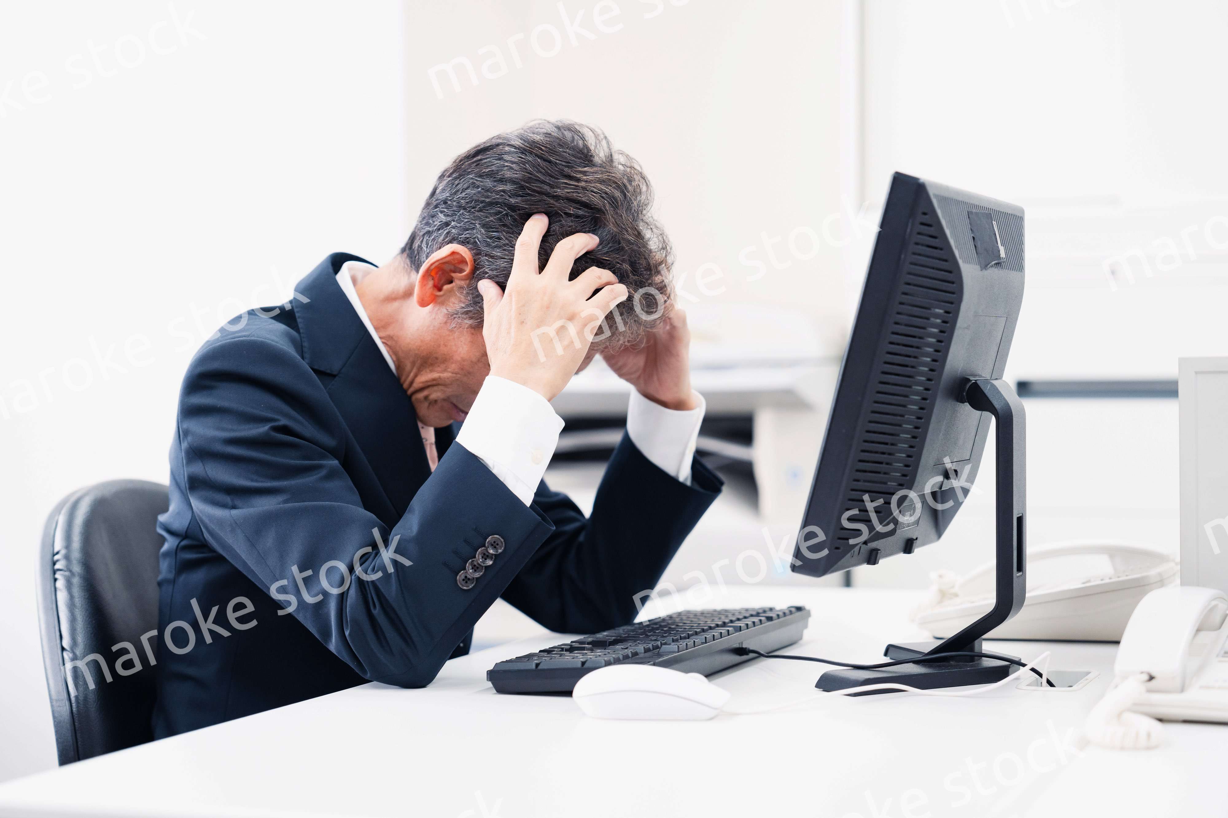 頭を抱えるミドルマネジメントの男性