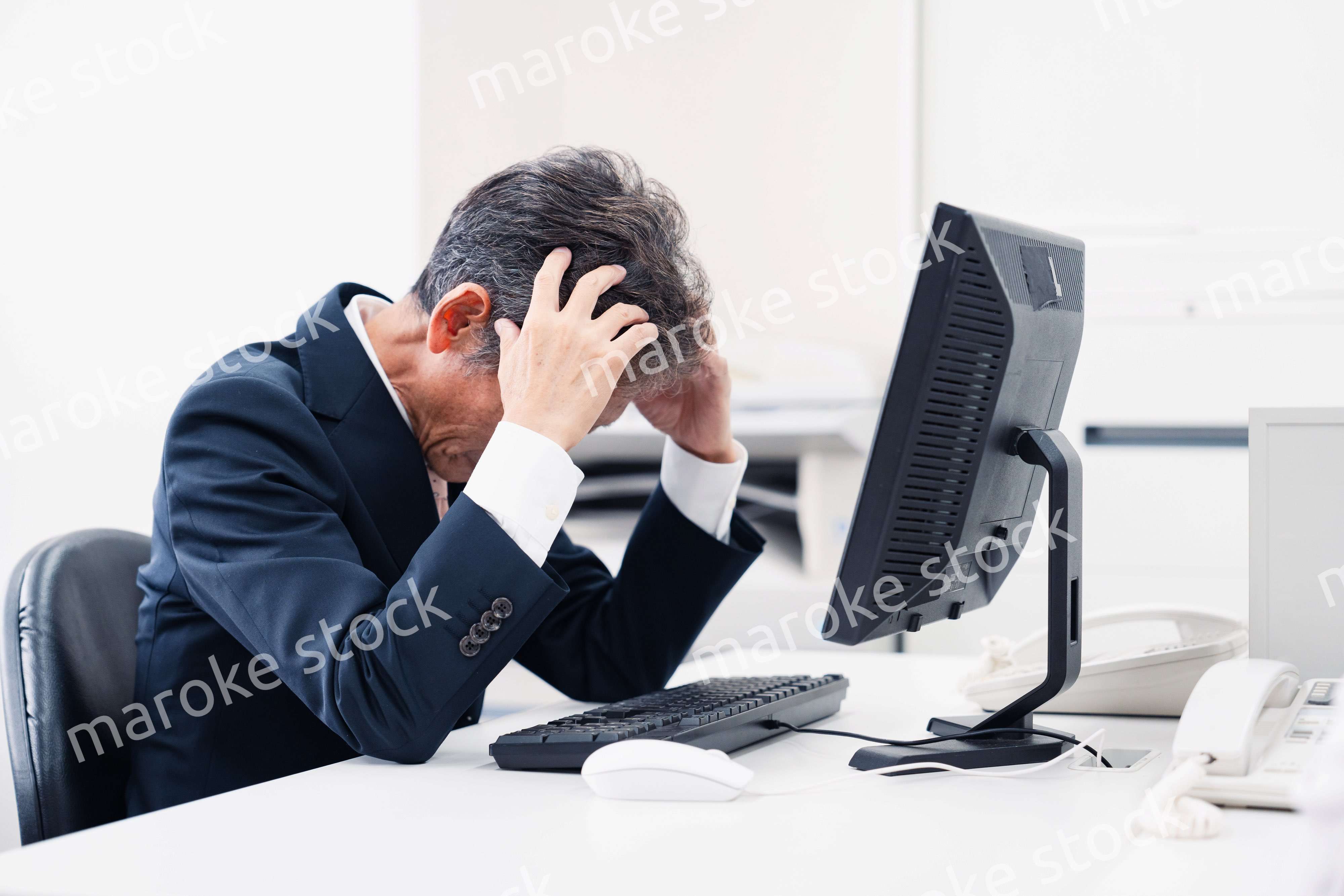 頭を抱えるミドルマネジメントの男性