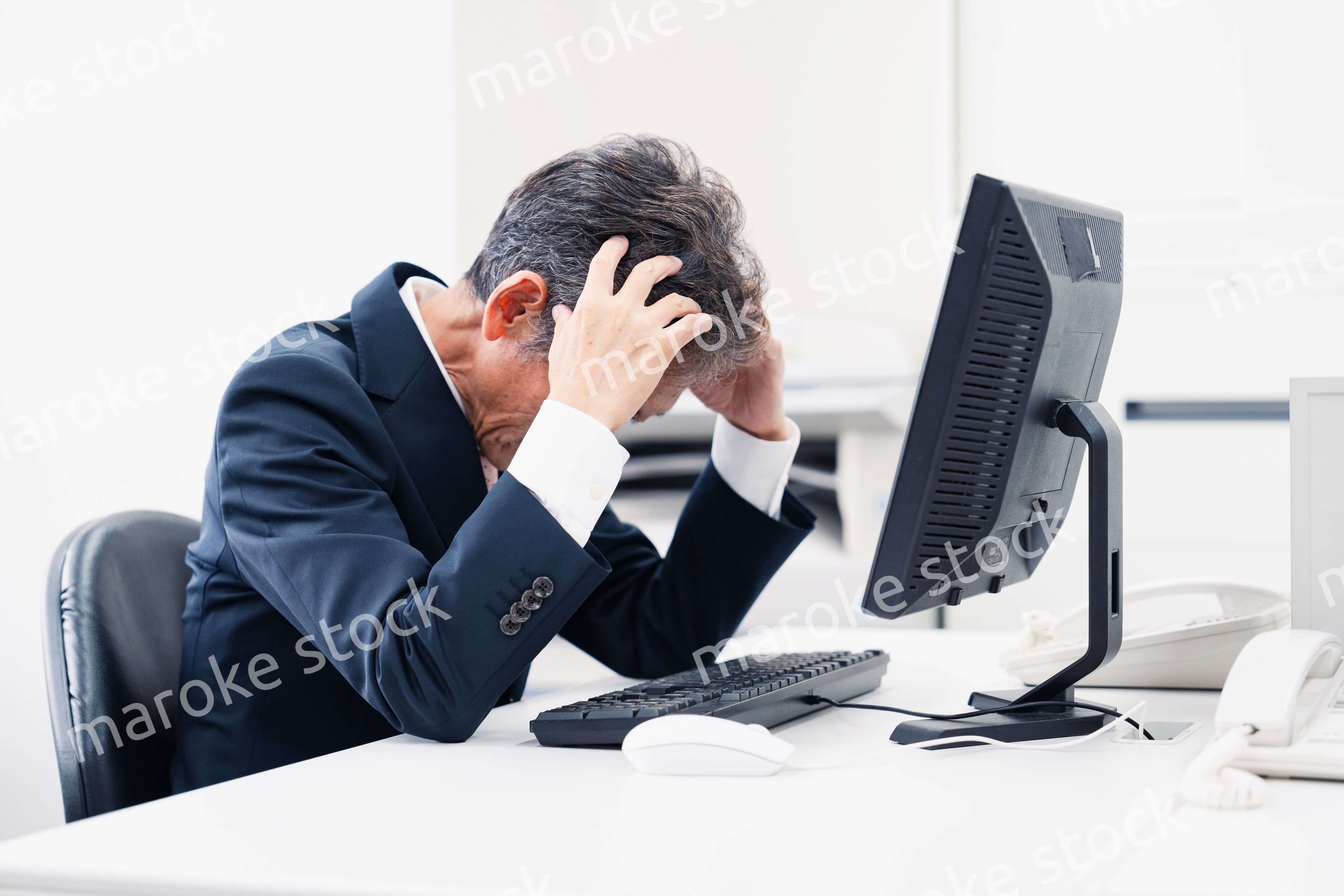 頭を抱えるミドルマネジメントの男性