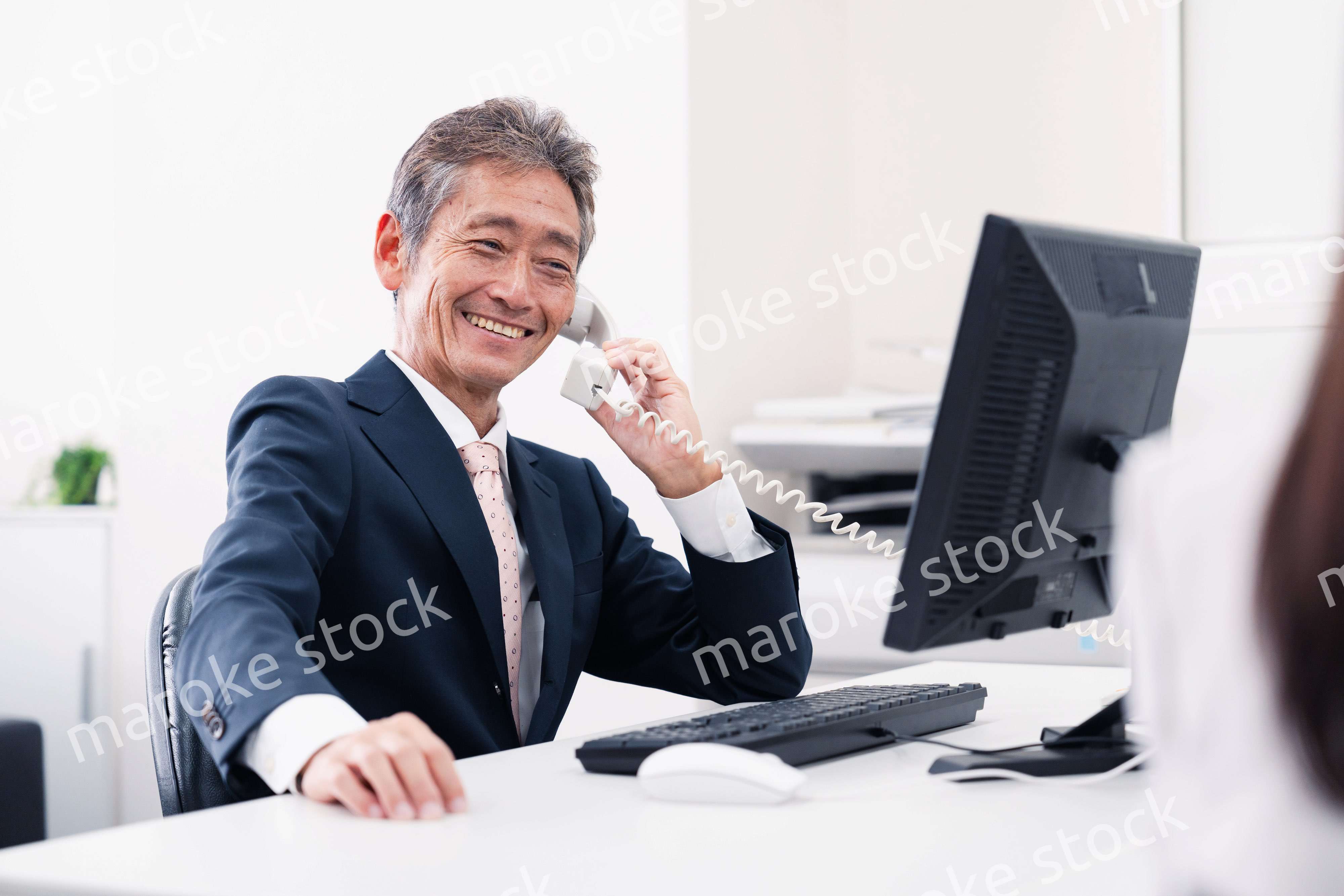 笑顔で電話をするミドルマネジメントの男性