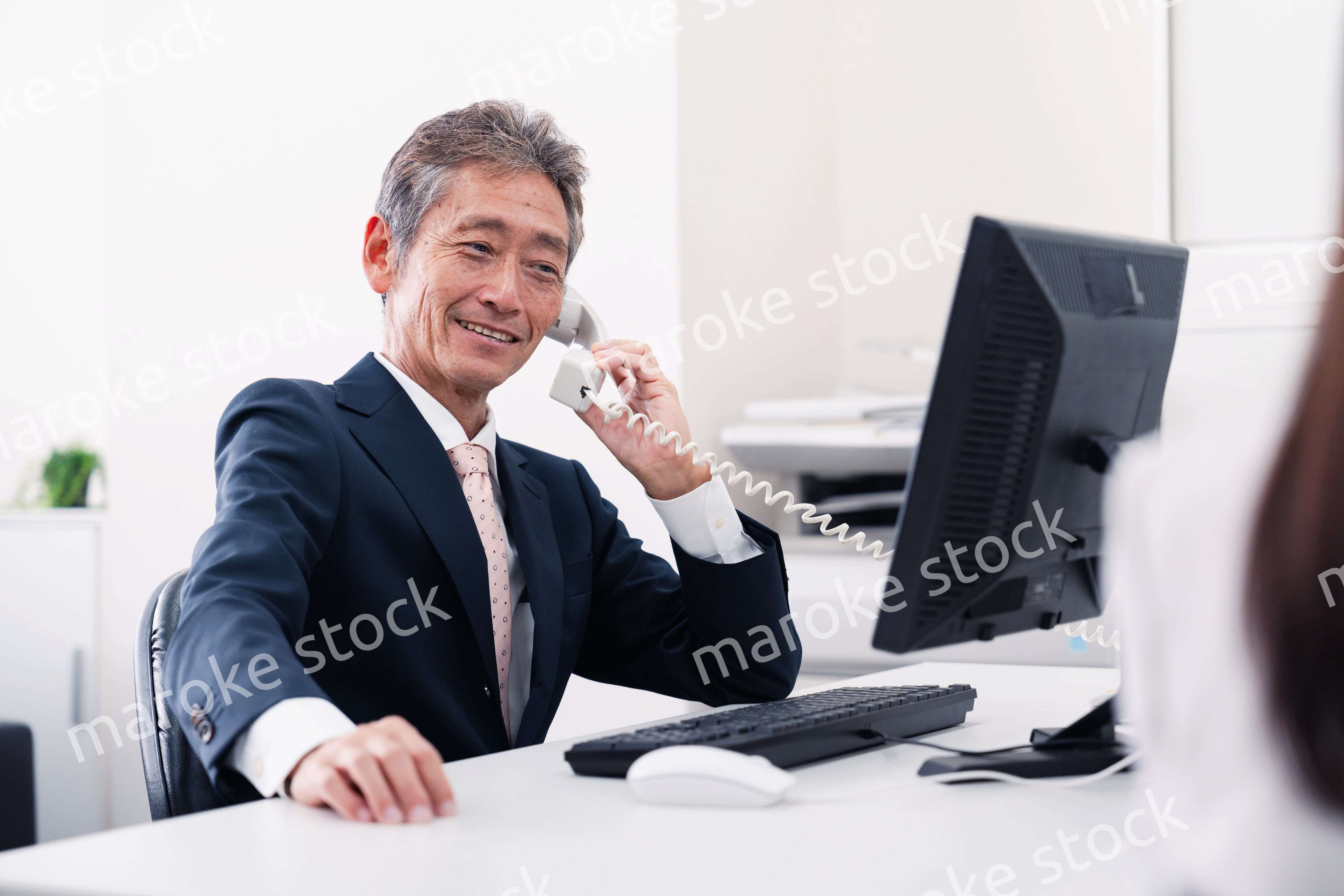 笑顔で電話をするミドルマネジメントの男性