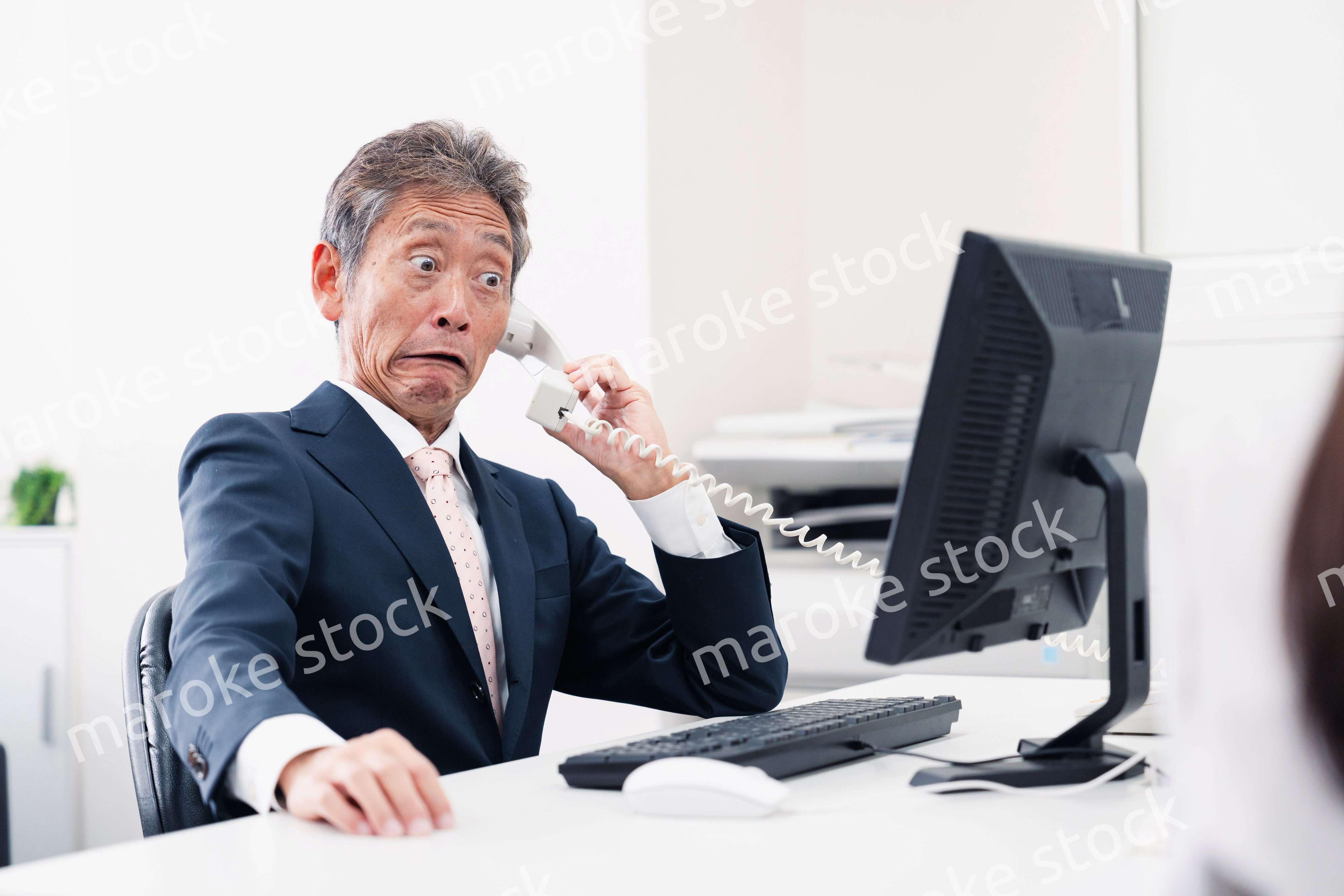 電話で驚く管理職の男性
