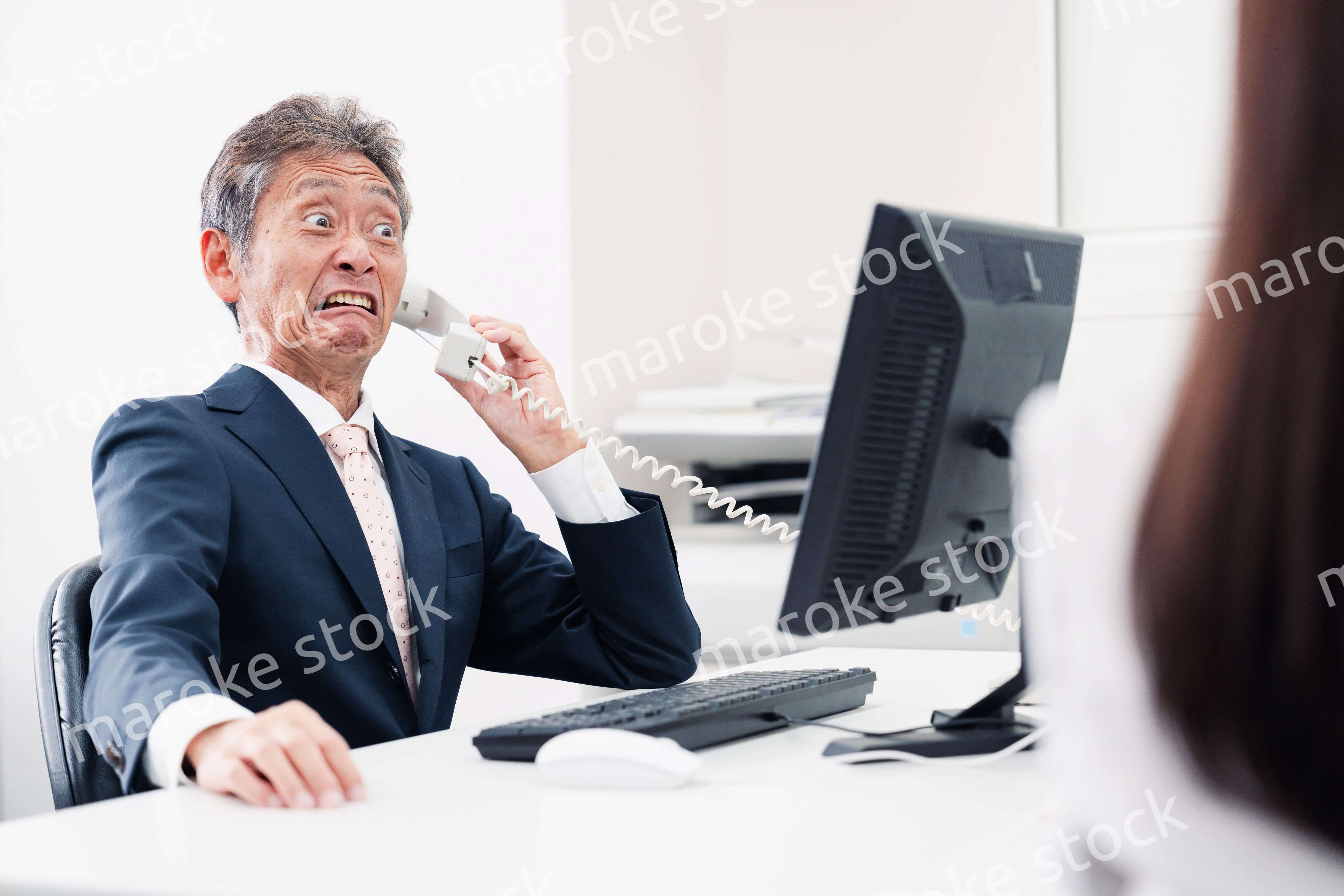 電話で驚く管理職の男性