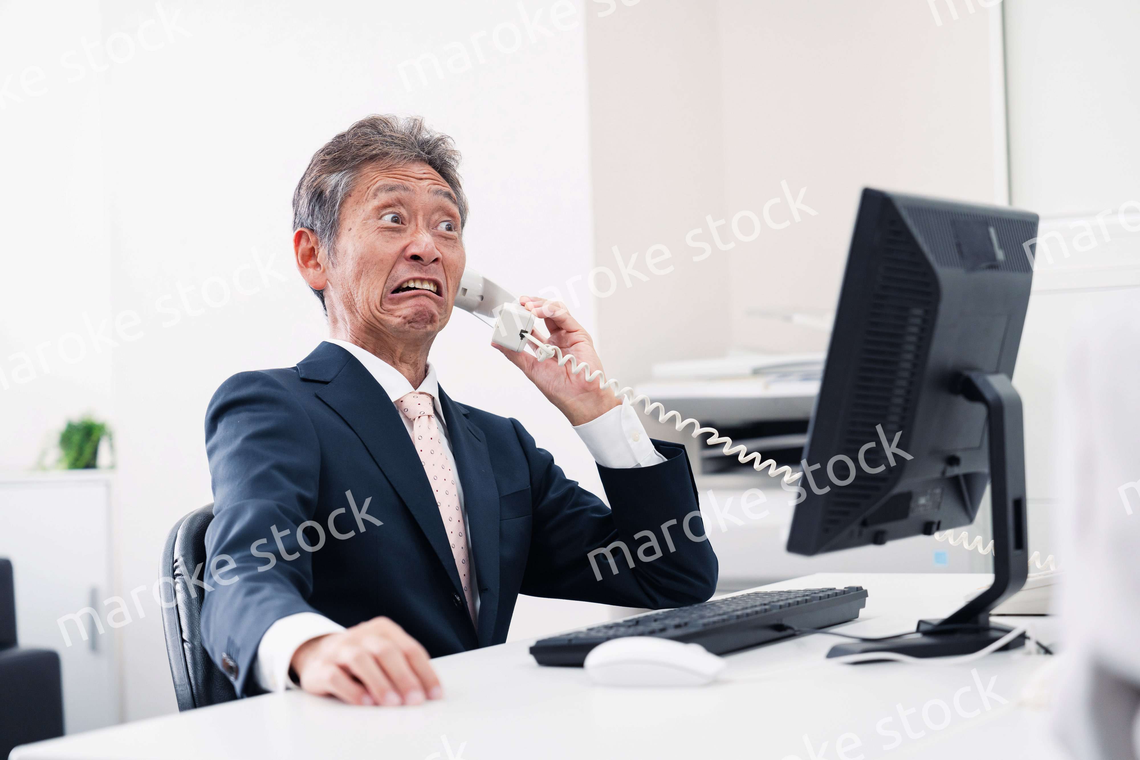 電話で驚く管理職の男性