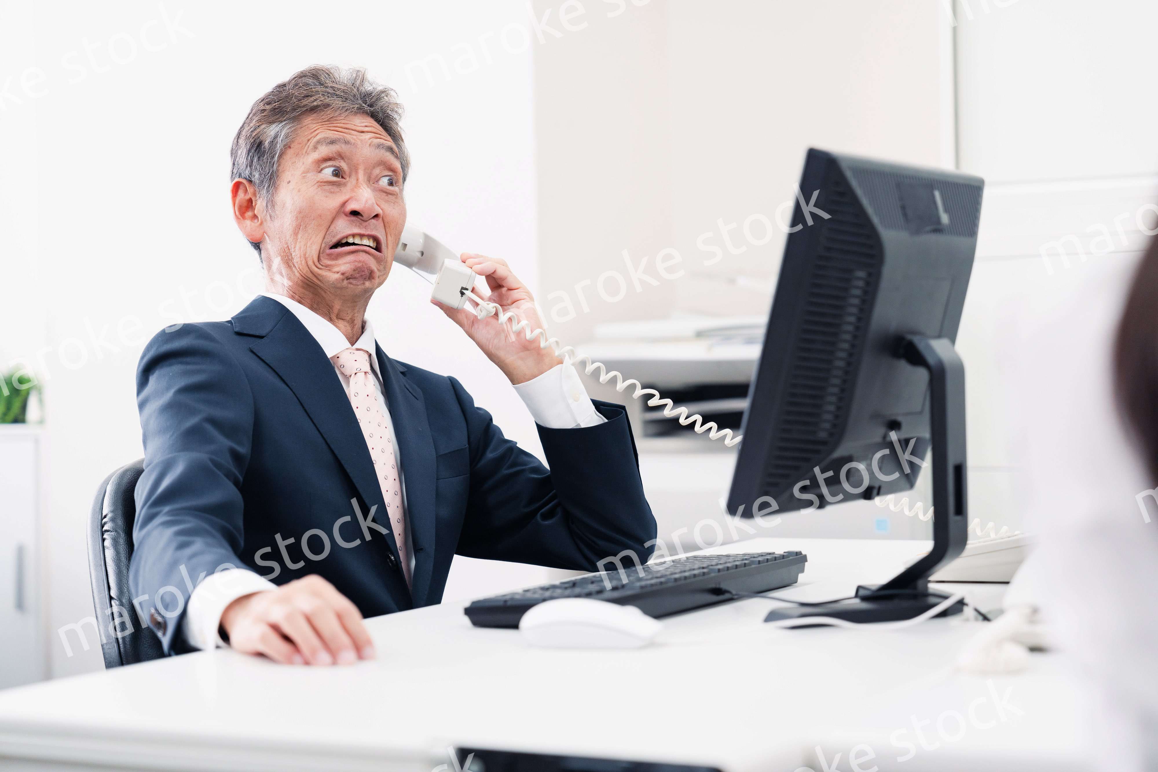 電話で驚く管理職の男性