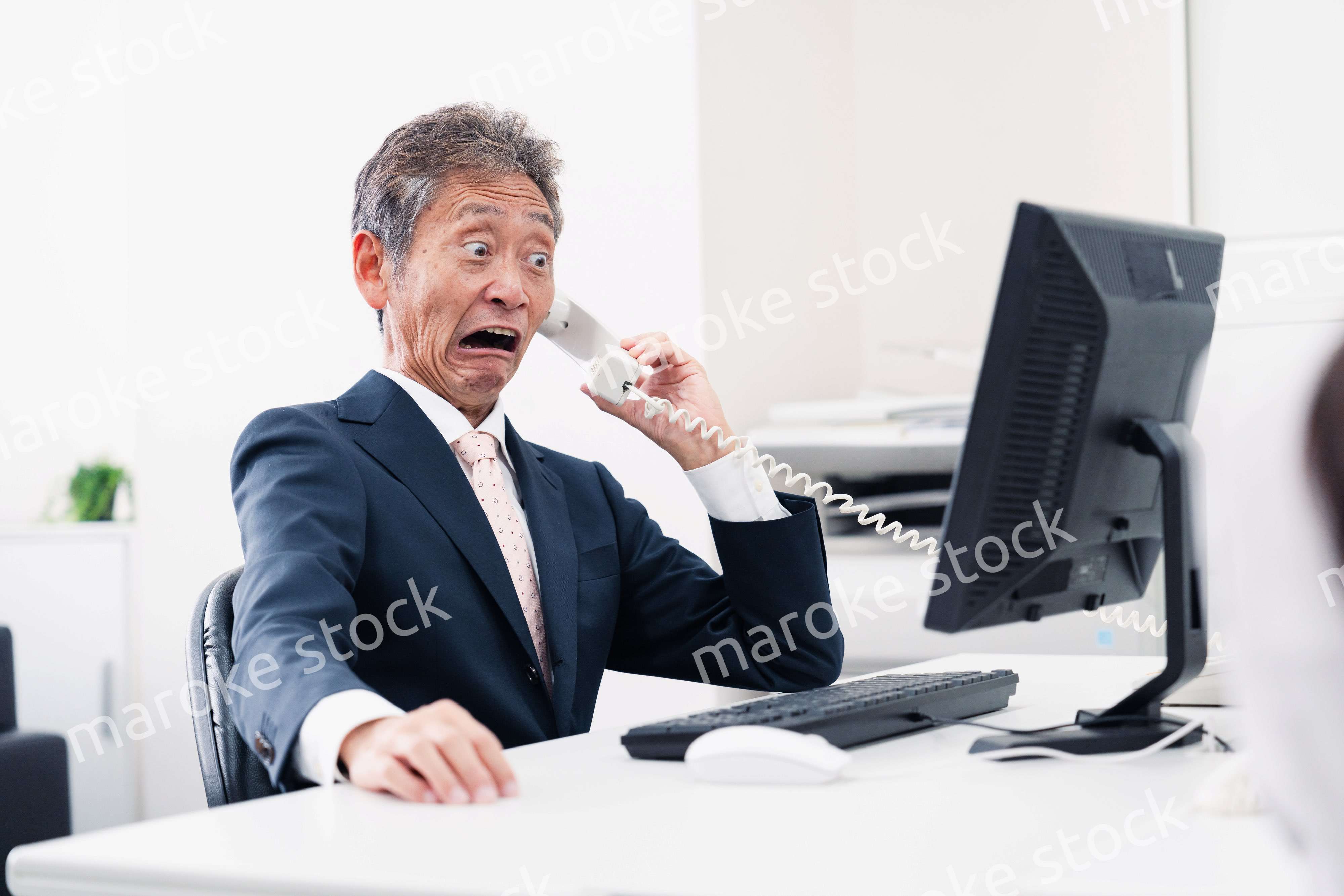 電話で驚く管理職の男性