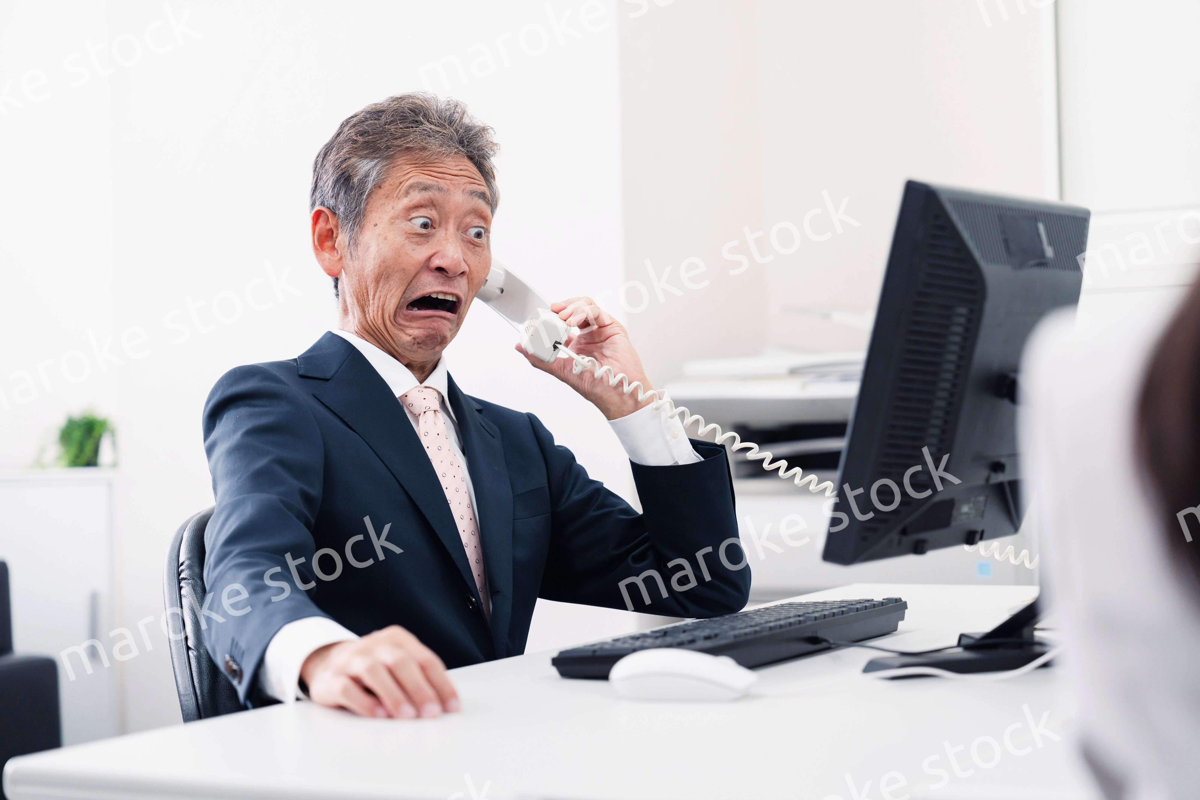 電話で驚く管理職の男性