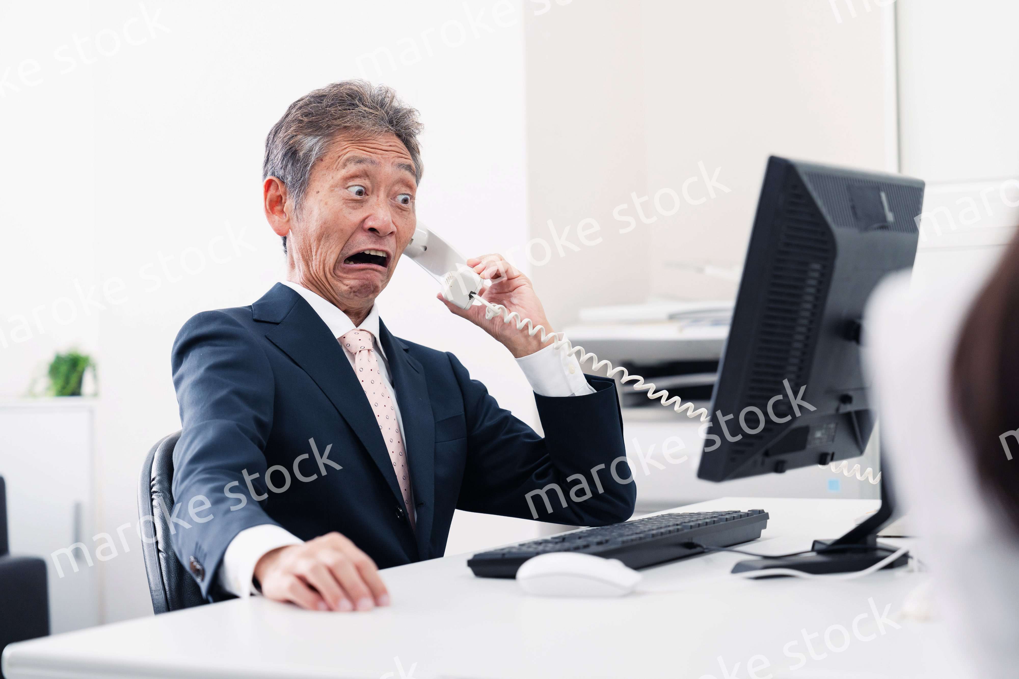 電話で驚く管理職の男性