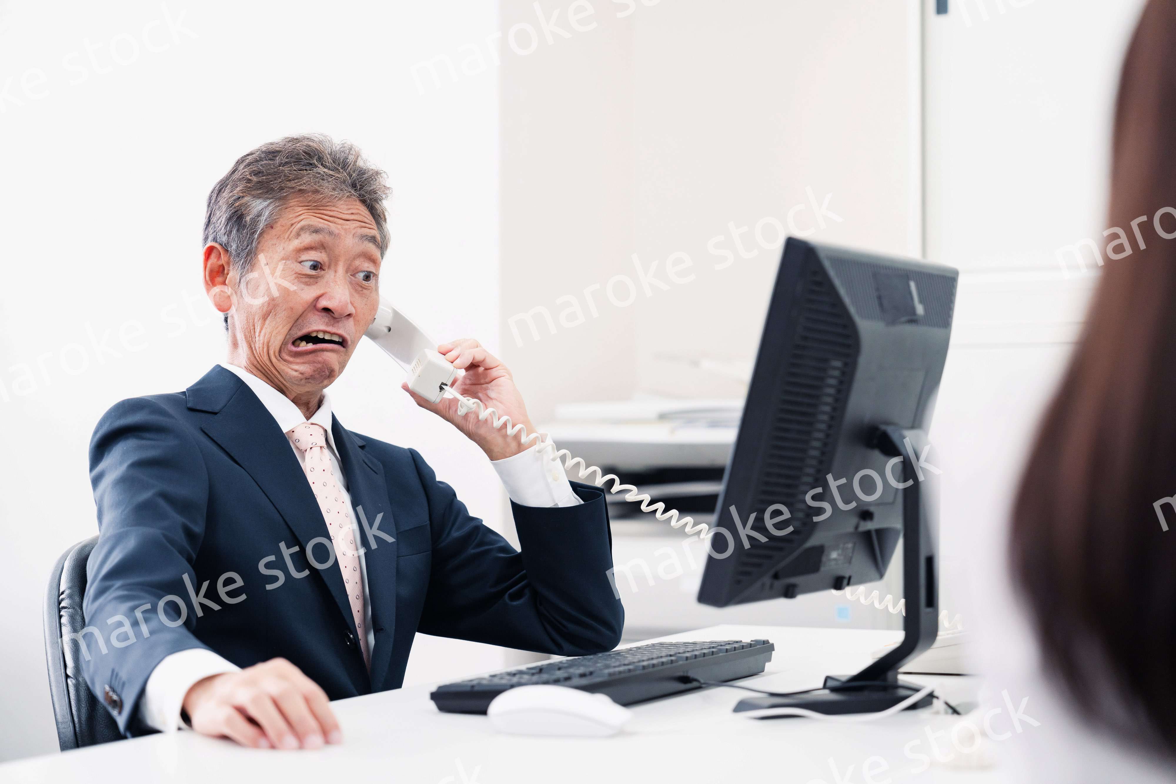 電話で驚く管理職の男性