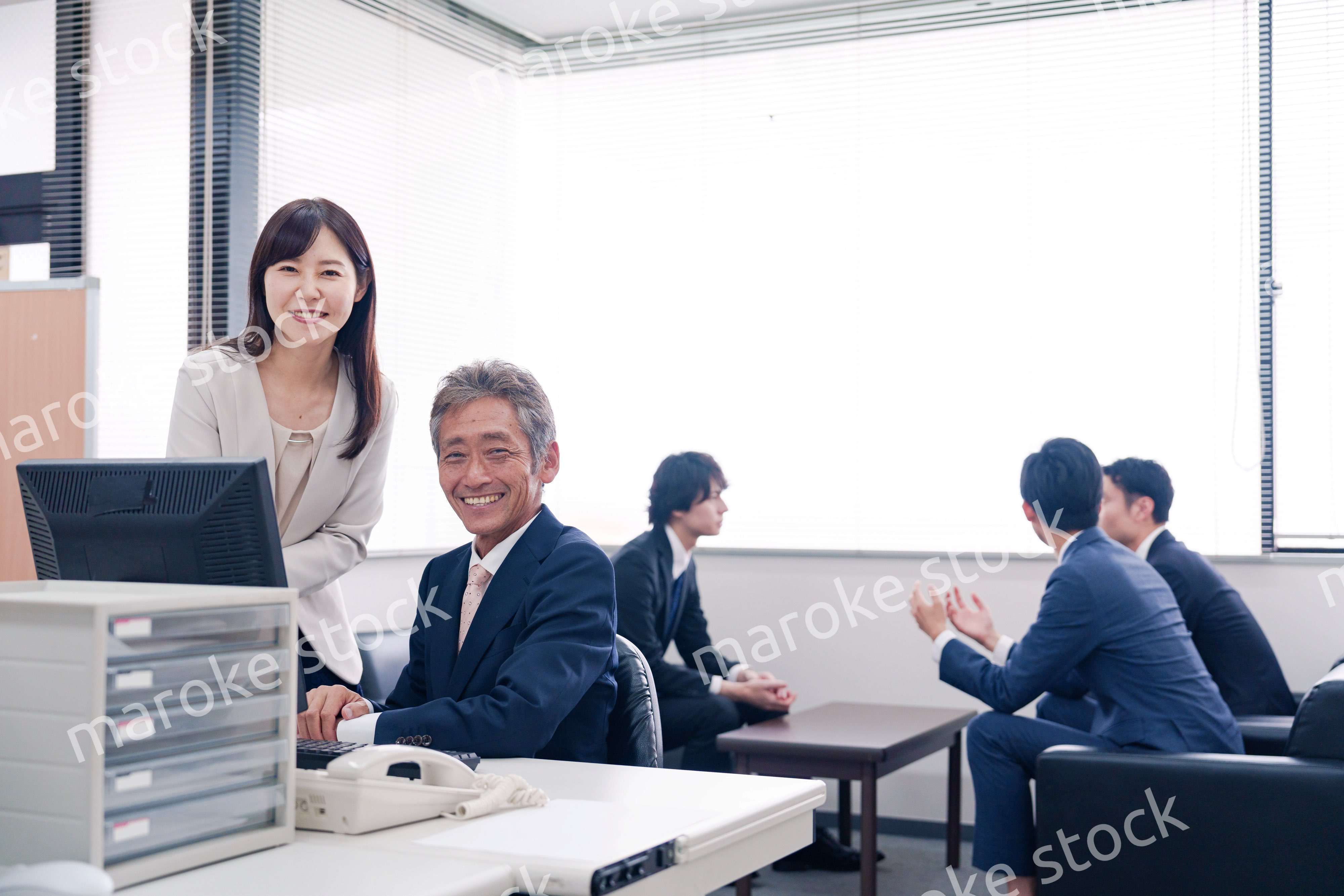 オフィスで上司に報告をするビジネスウーマン