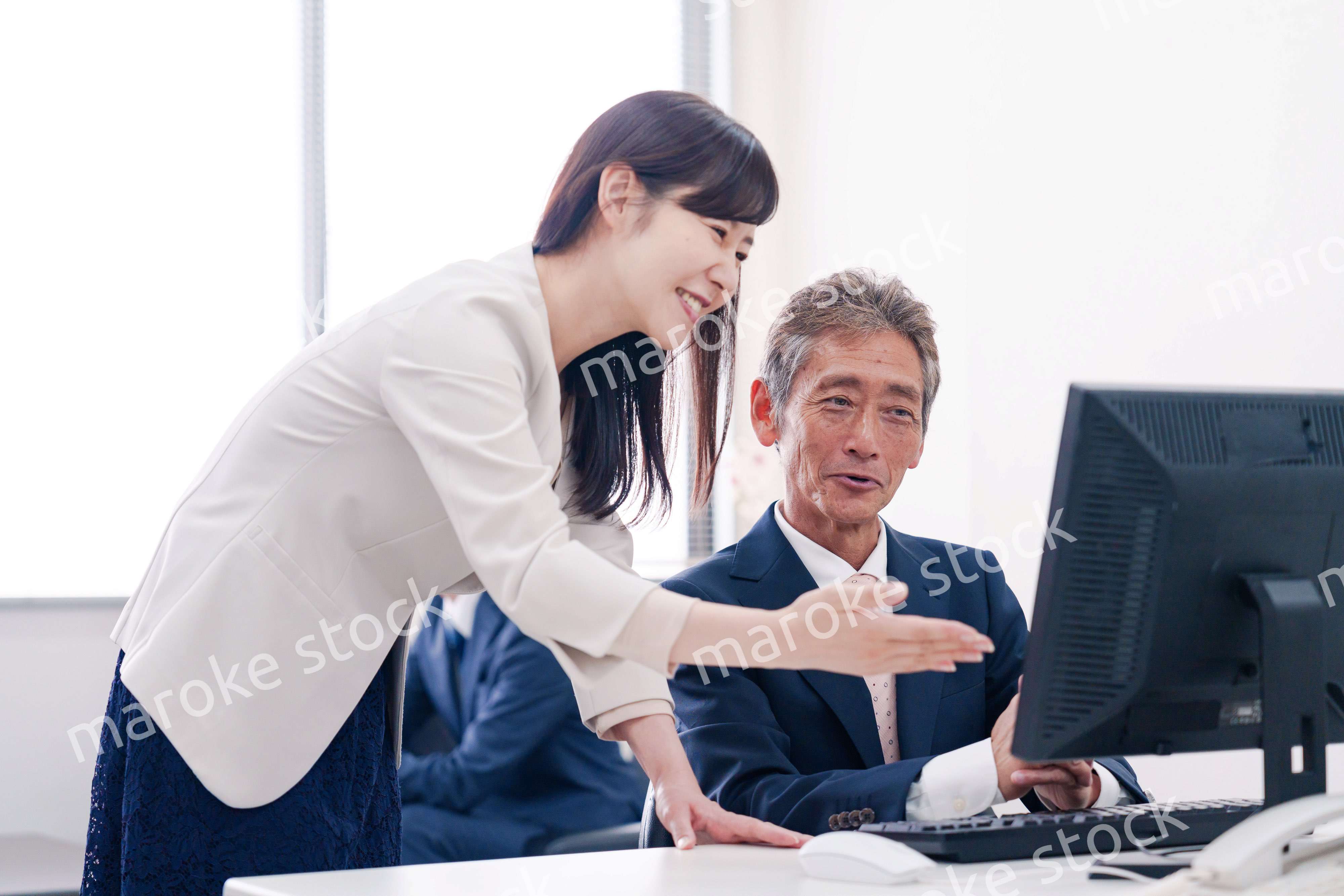 オフィスで上司に報告をするビジネスウーマン