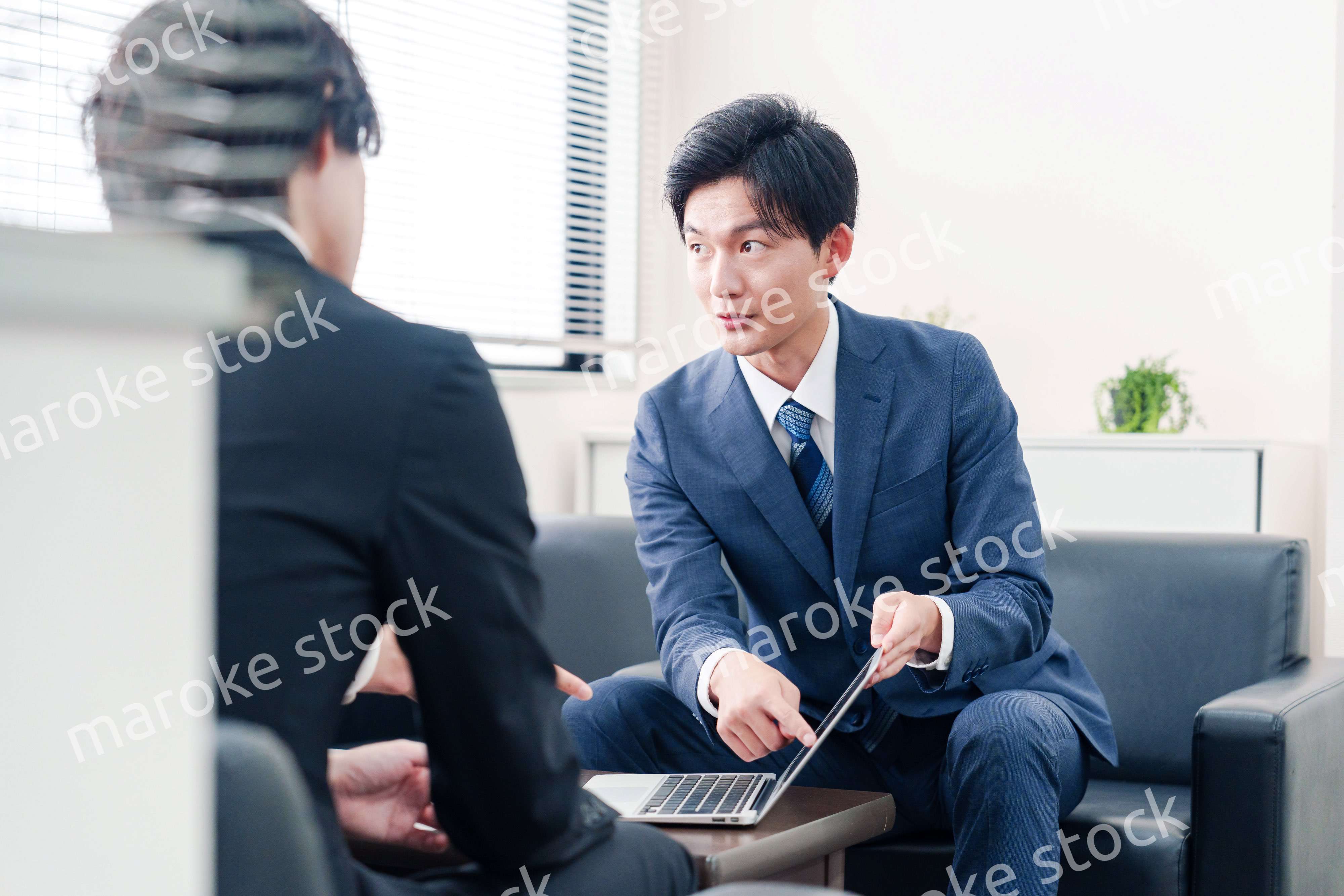 得意先と商談をするスーツを着たビジネスマン