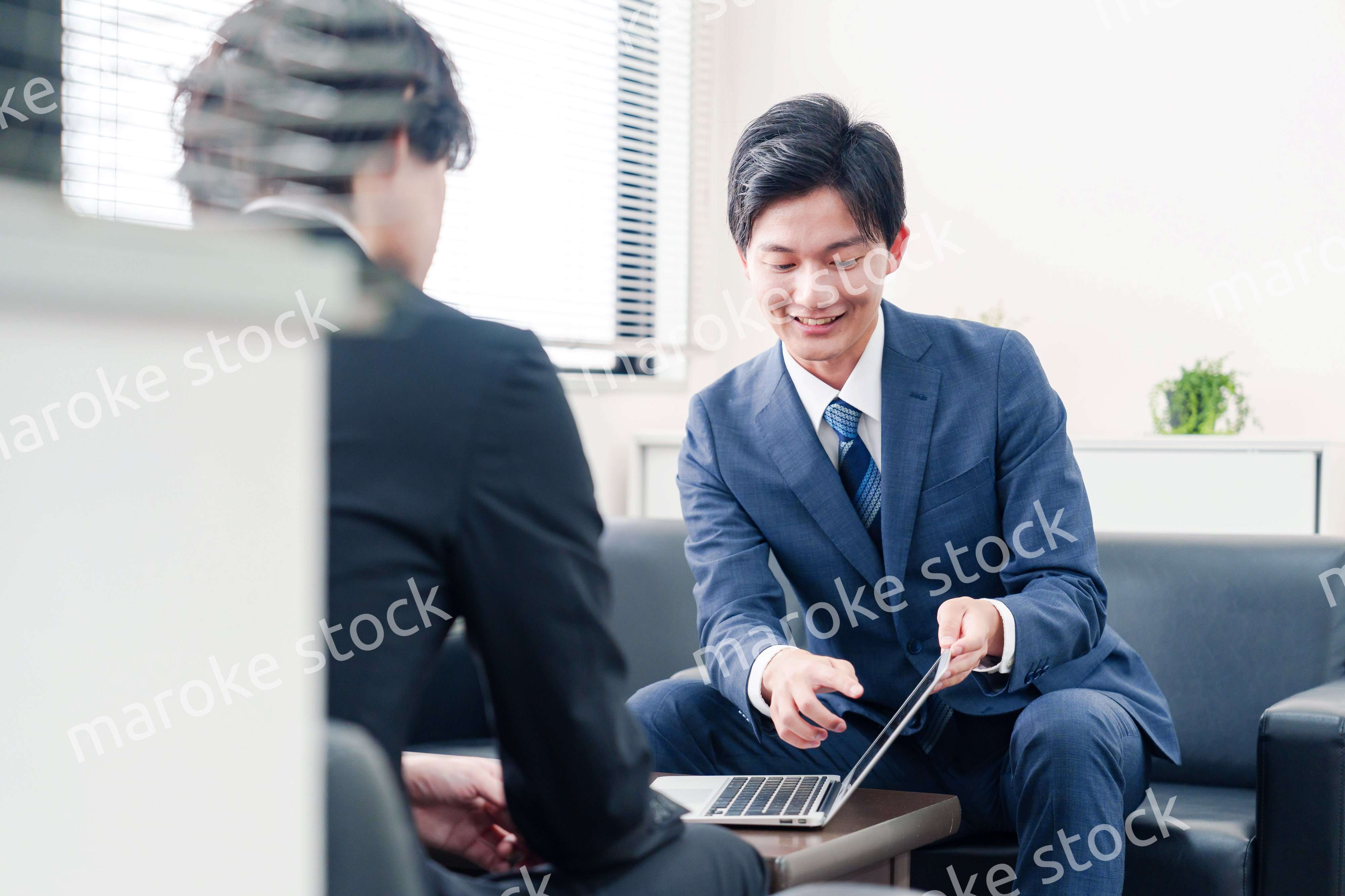 得意先と商談をするスーツを着たビジネスマン