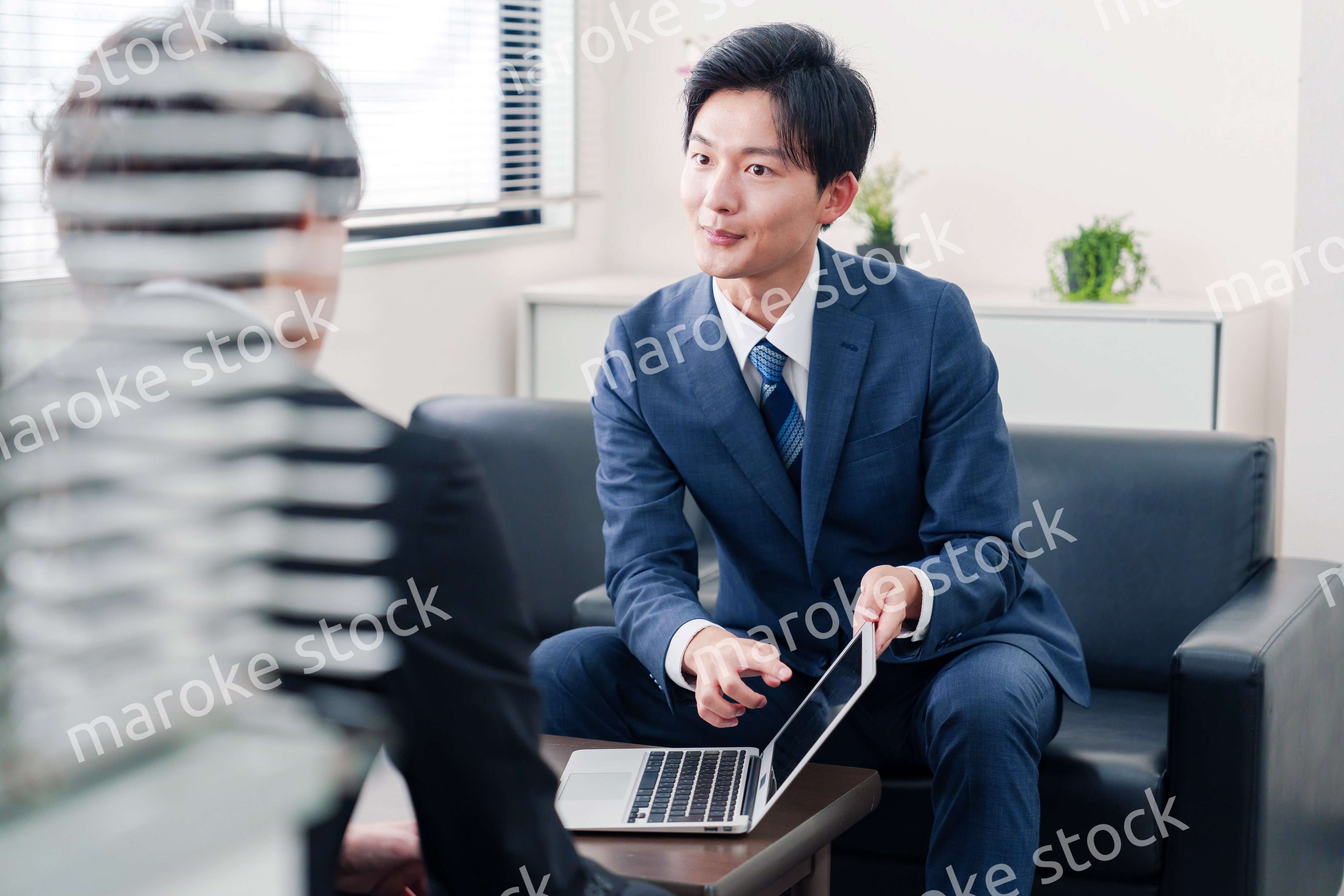 得意先と商談をするスーツを着たビジネスマン