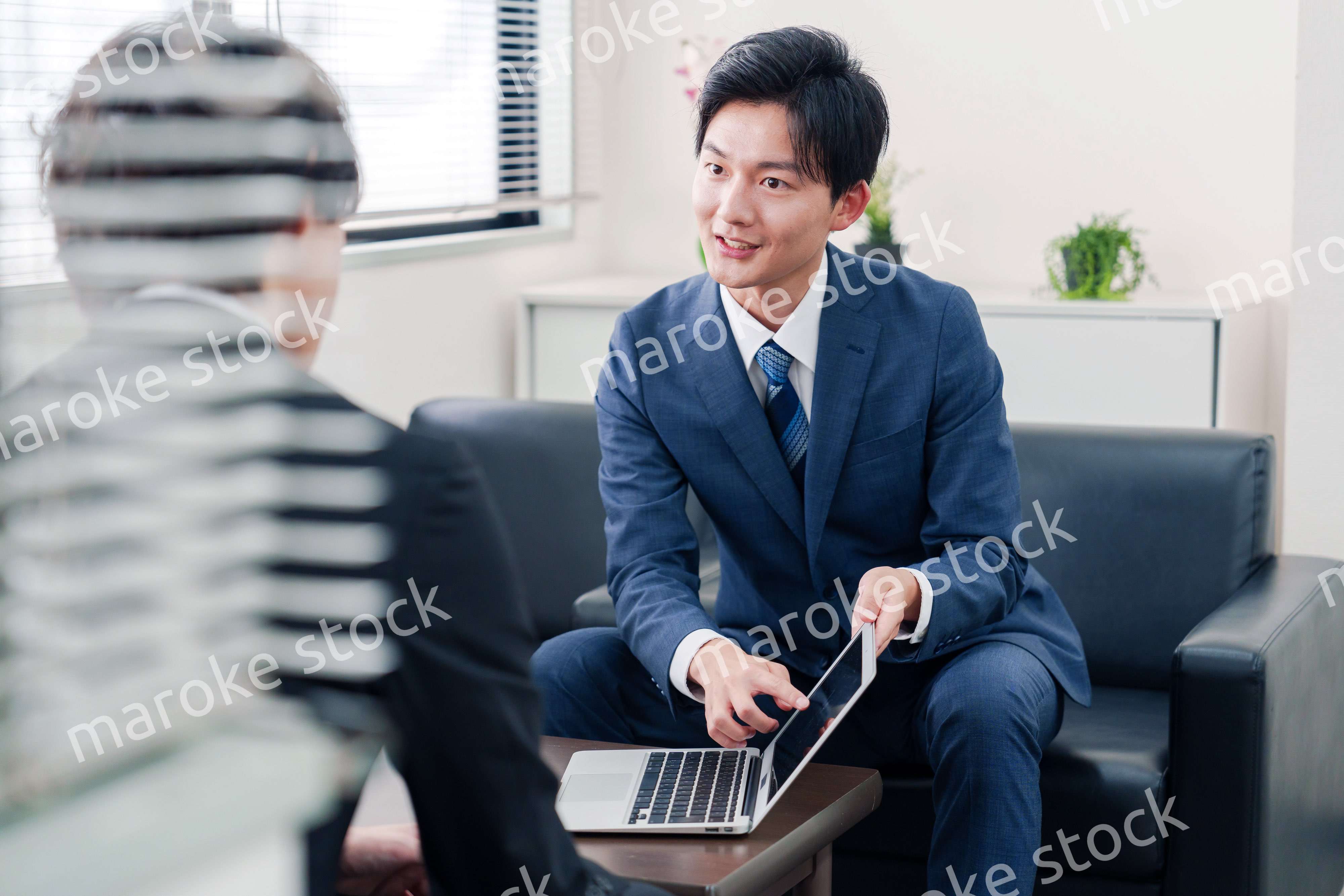 得意先と商談をするスーツを着たビジネスマン