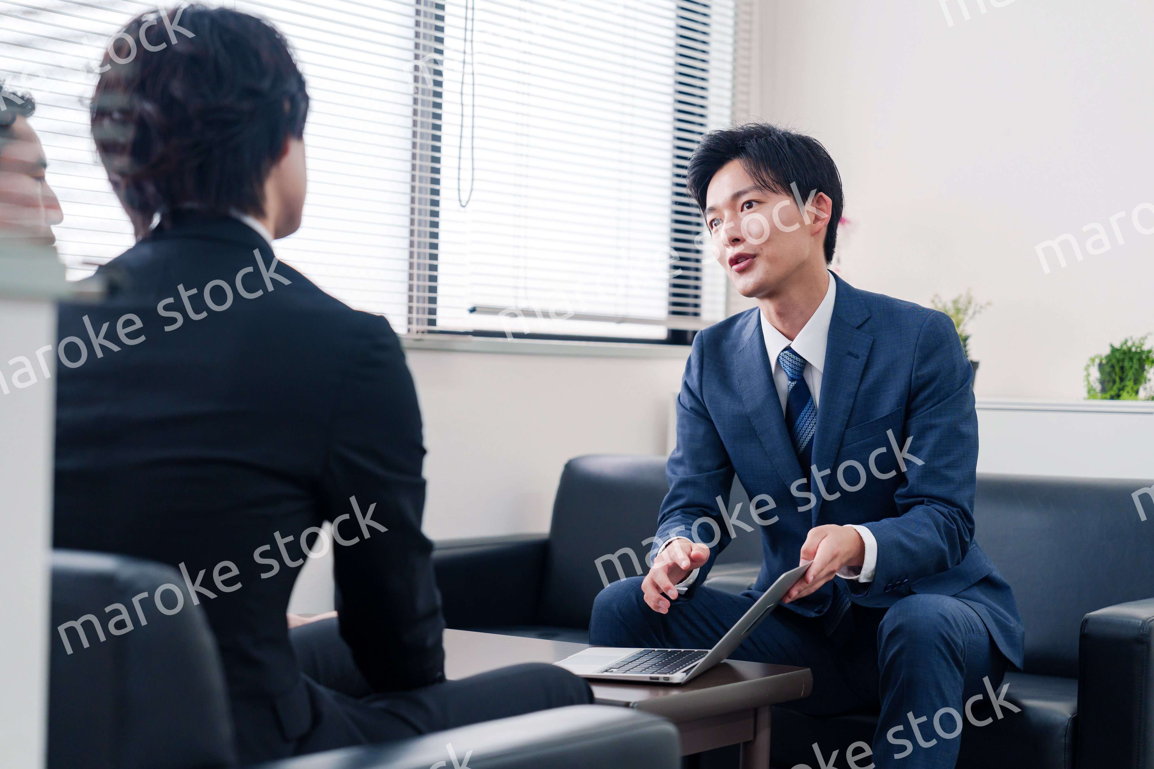 得意先と商談をするスーツを着たビジネスマン
