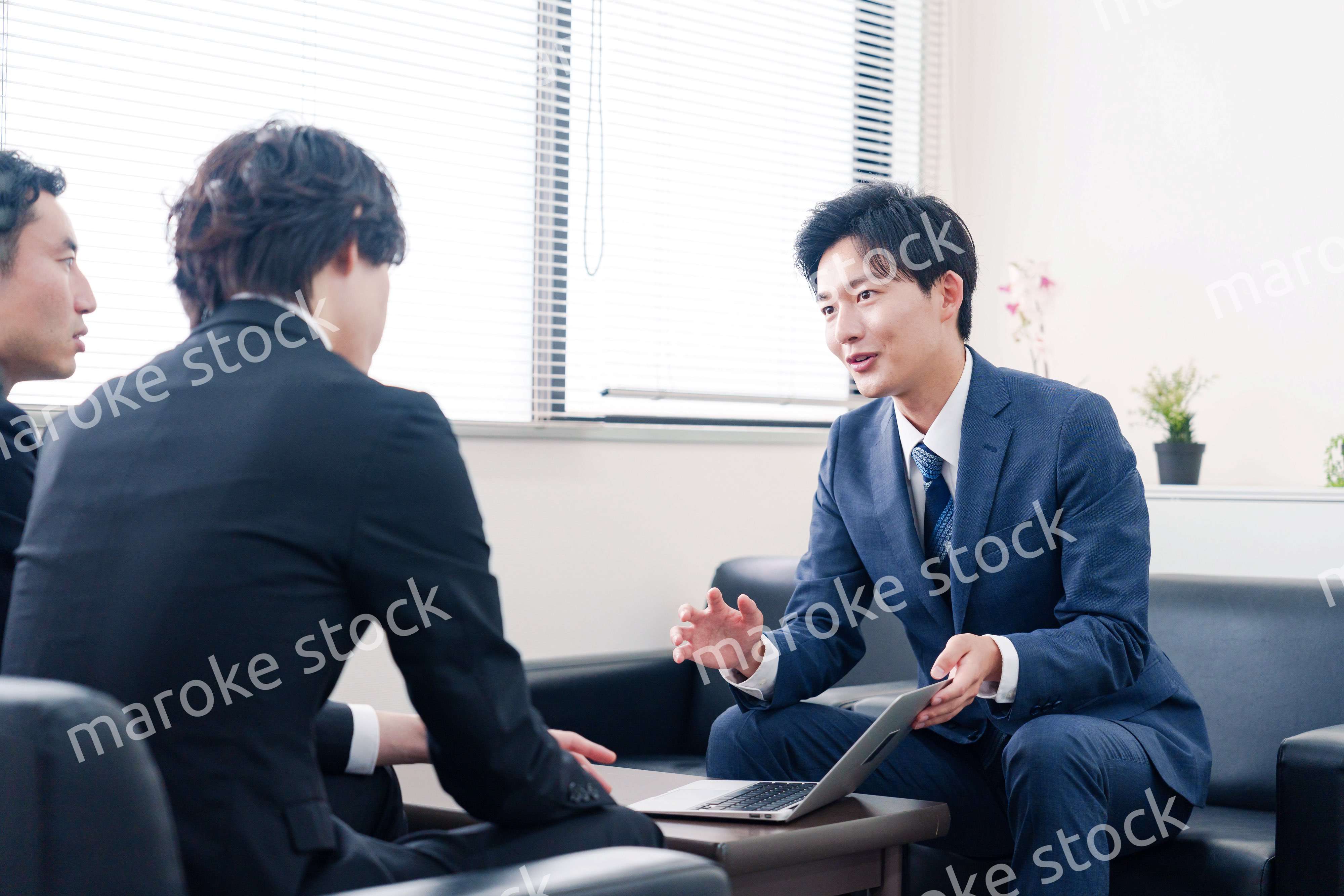 得意先と商談をするスーツを着たビジネスマン