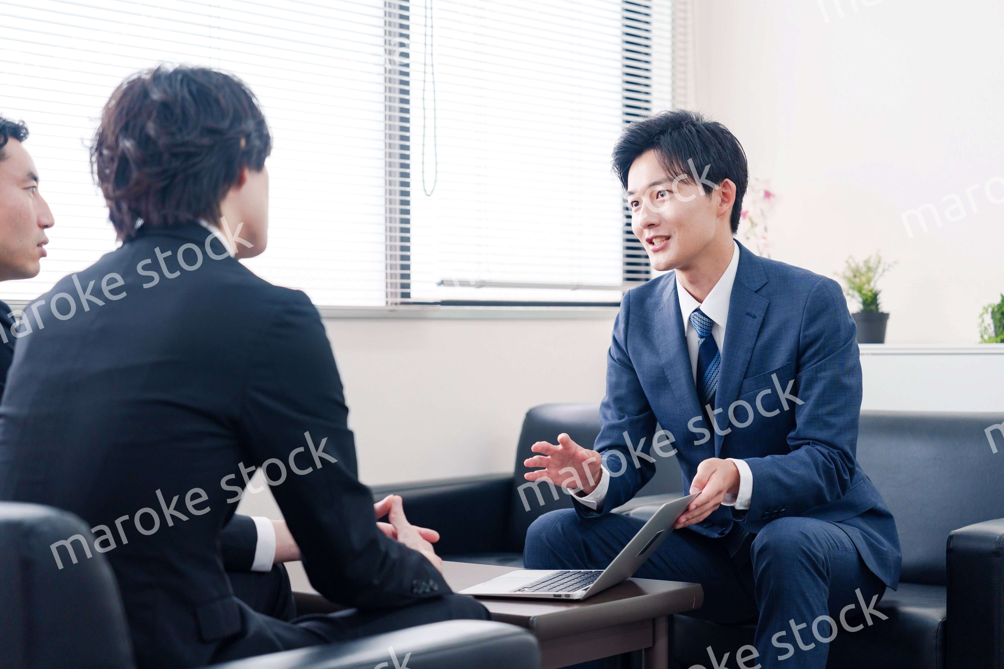 得意先と商談をするスーツを着たビジネスマン