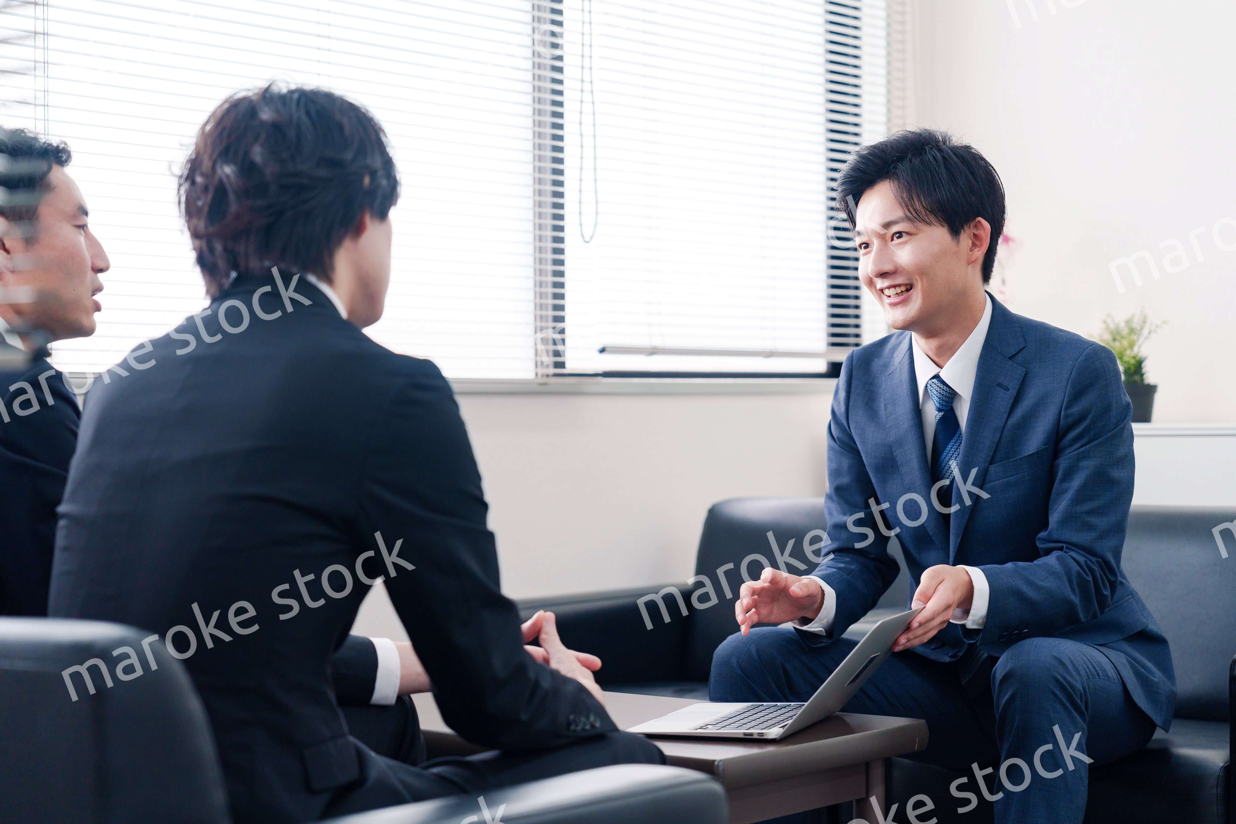 得意先と商談をするスーツを着たビジネスマン