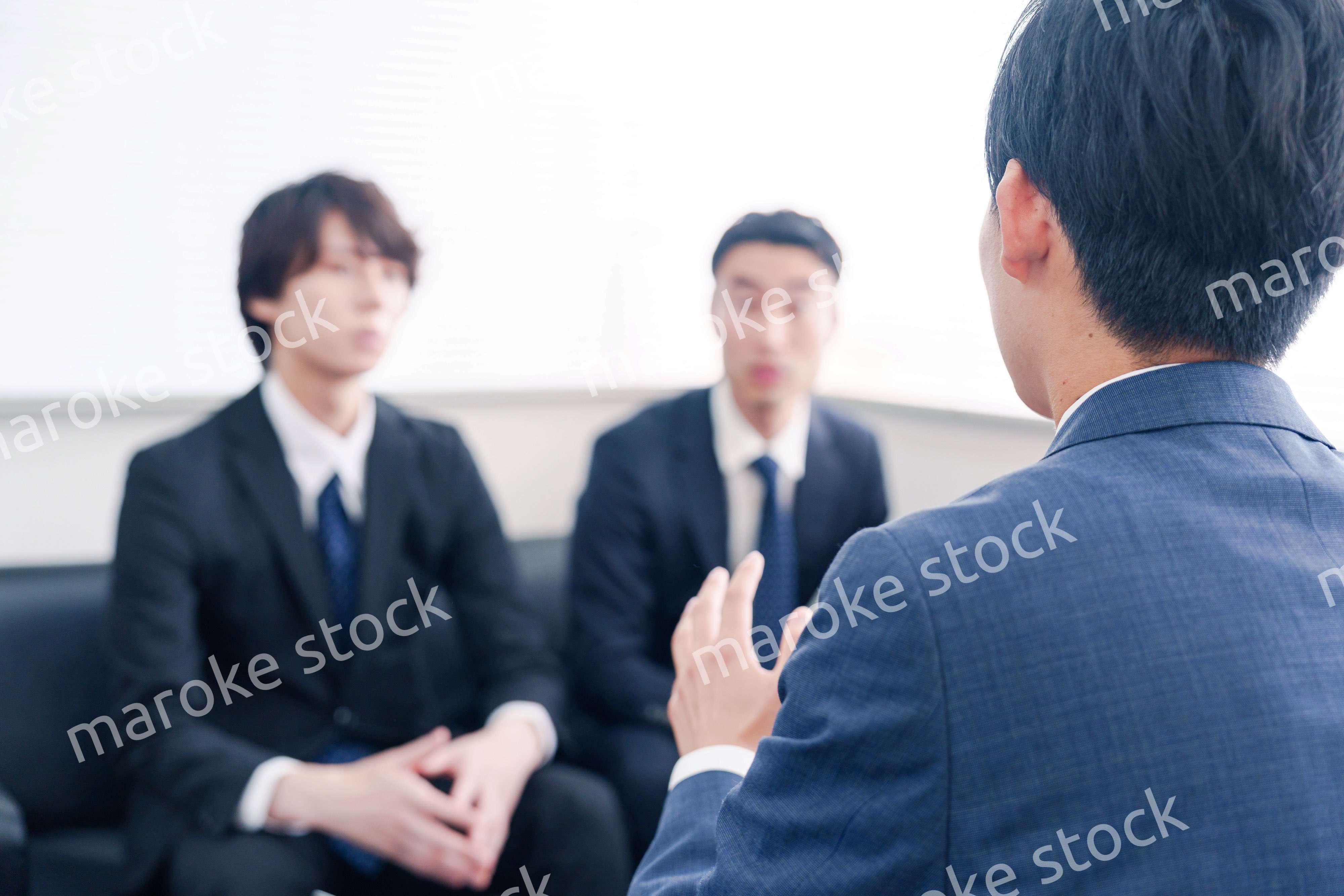 得意先と商談をするスーツを着たビジネスマン