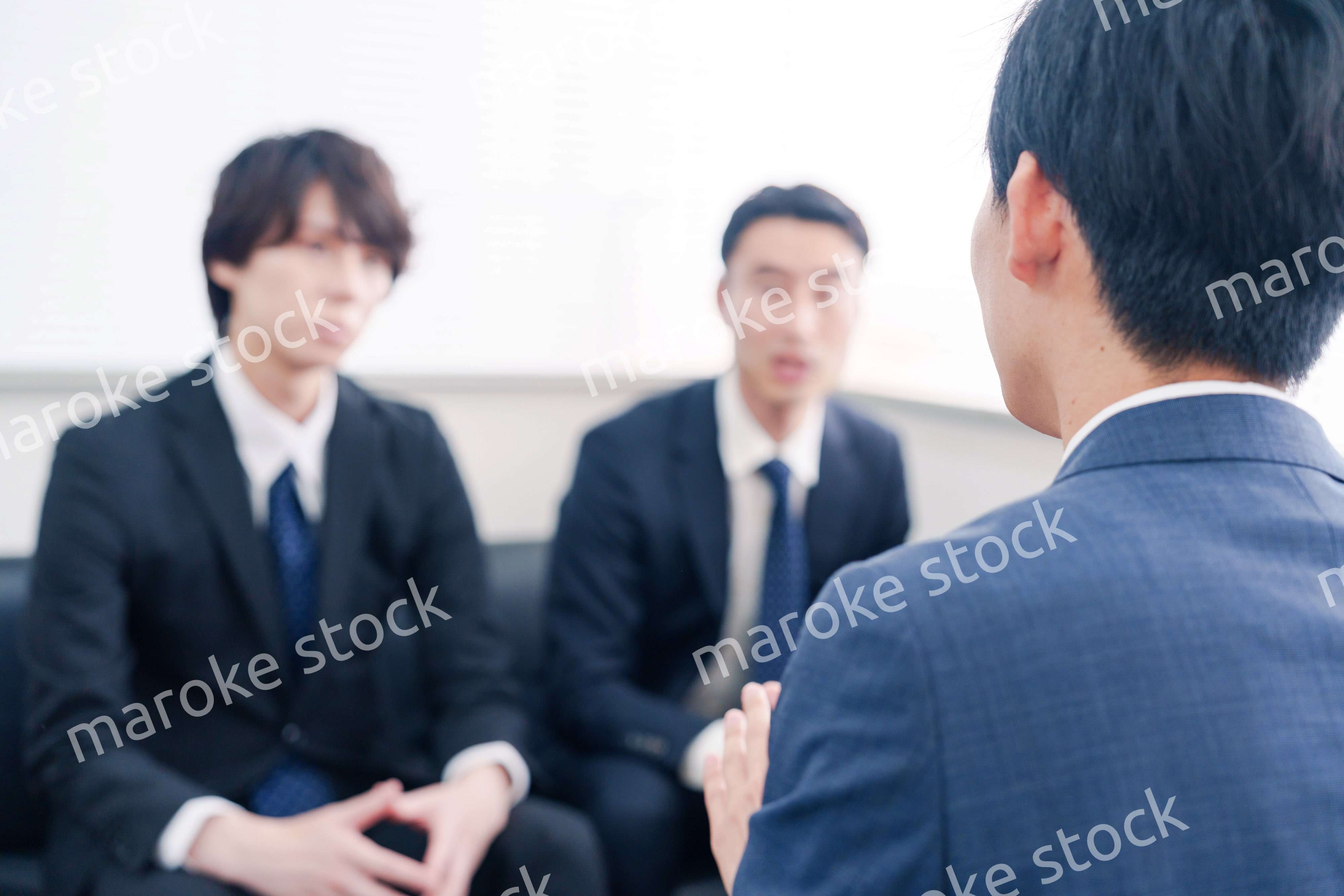 得意先と商談をするスーツを着たビジネスマン