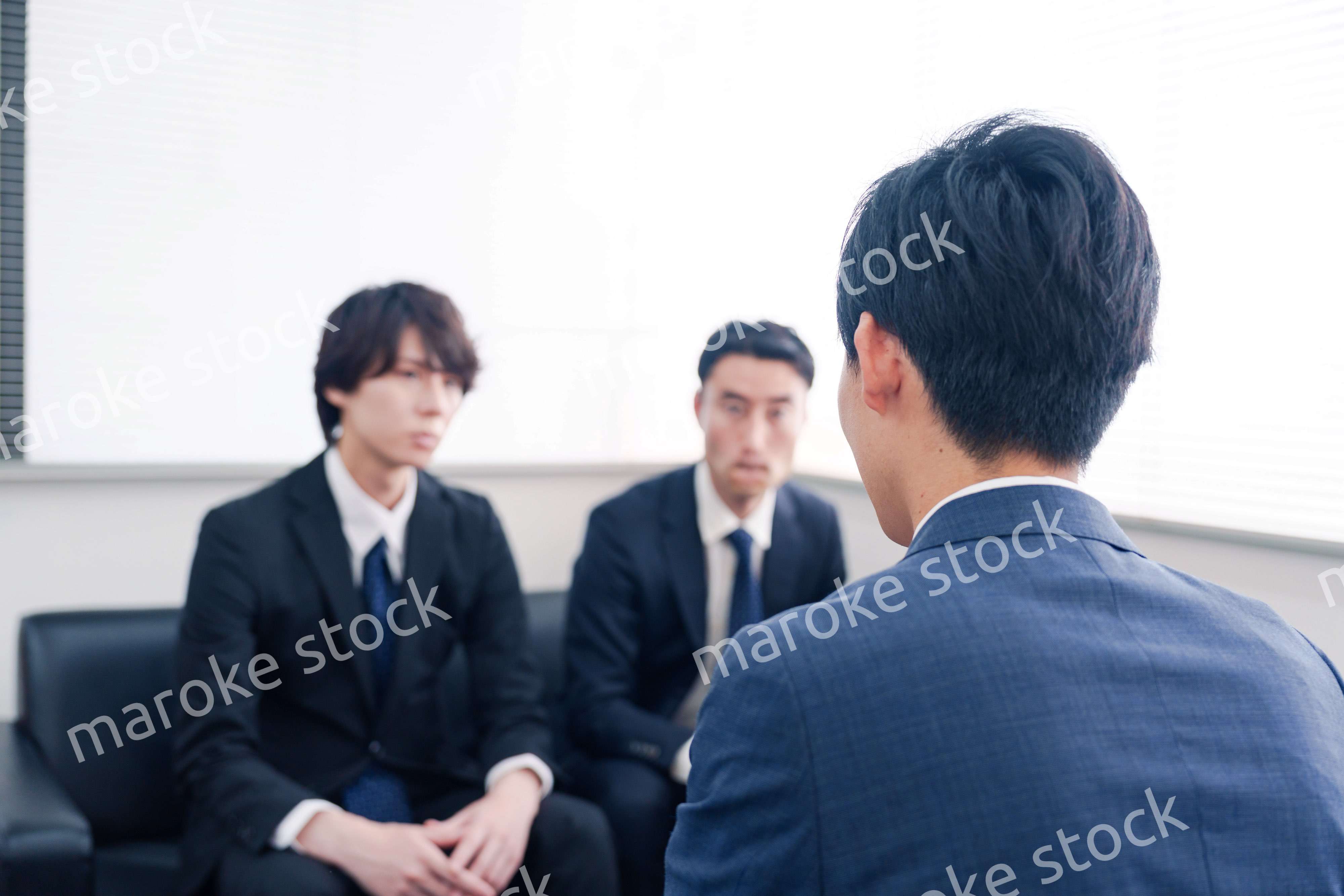 得意先と商談をするスーツを着たビジネスマン