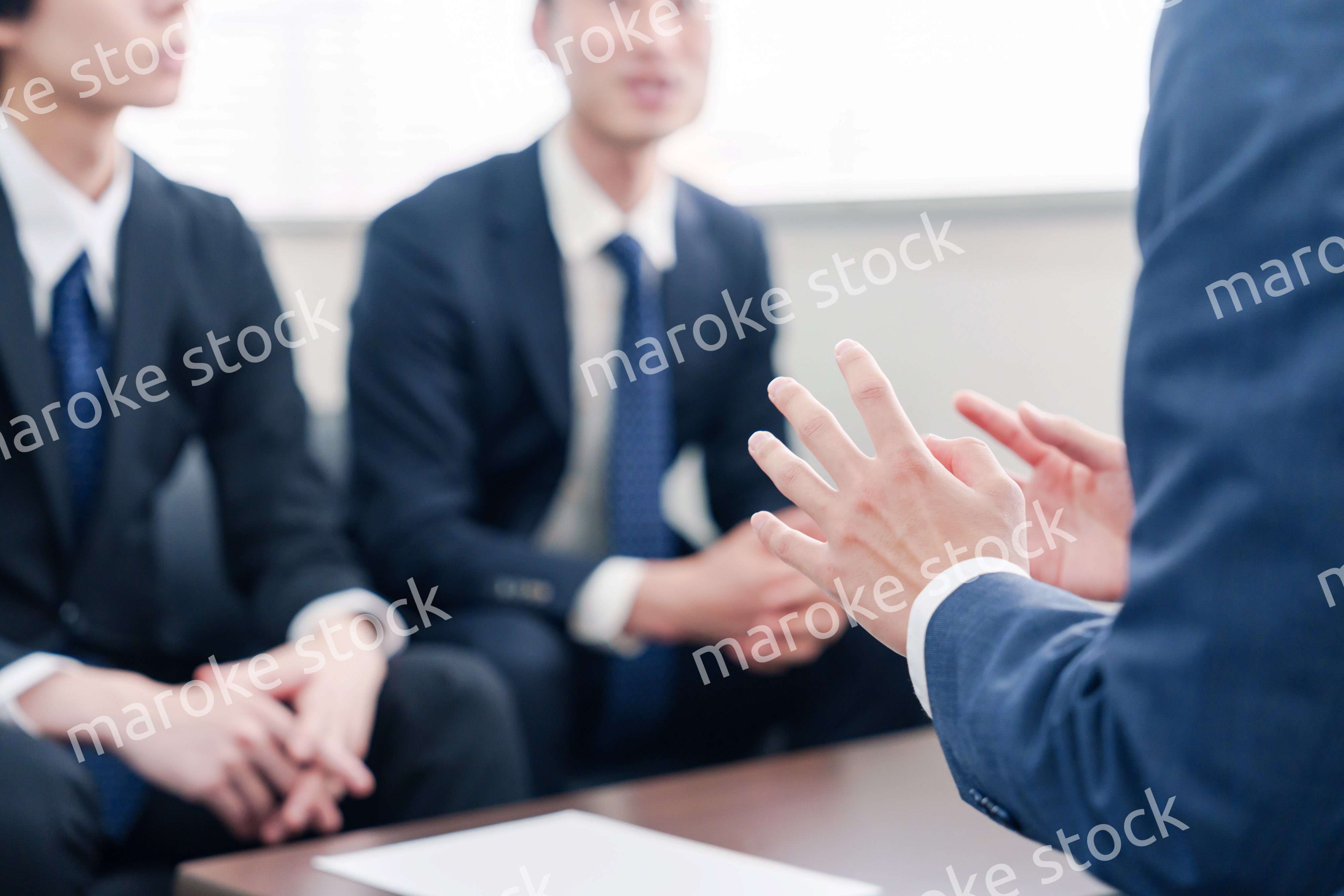 得意先と商談をするスーツを着たビジネスマン