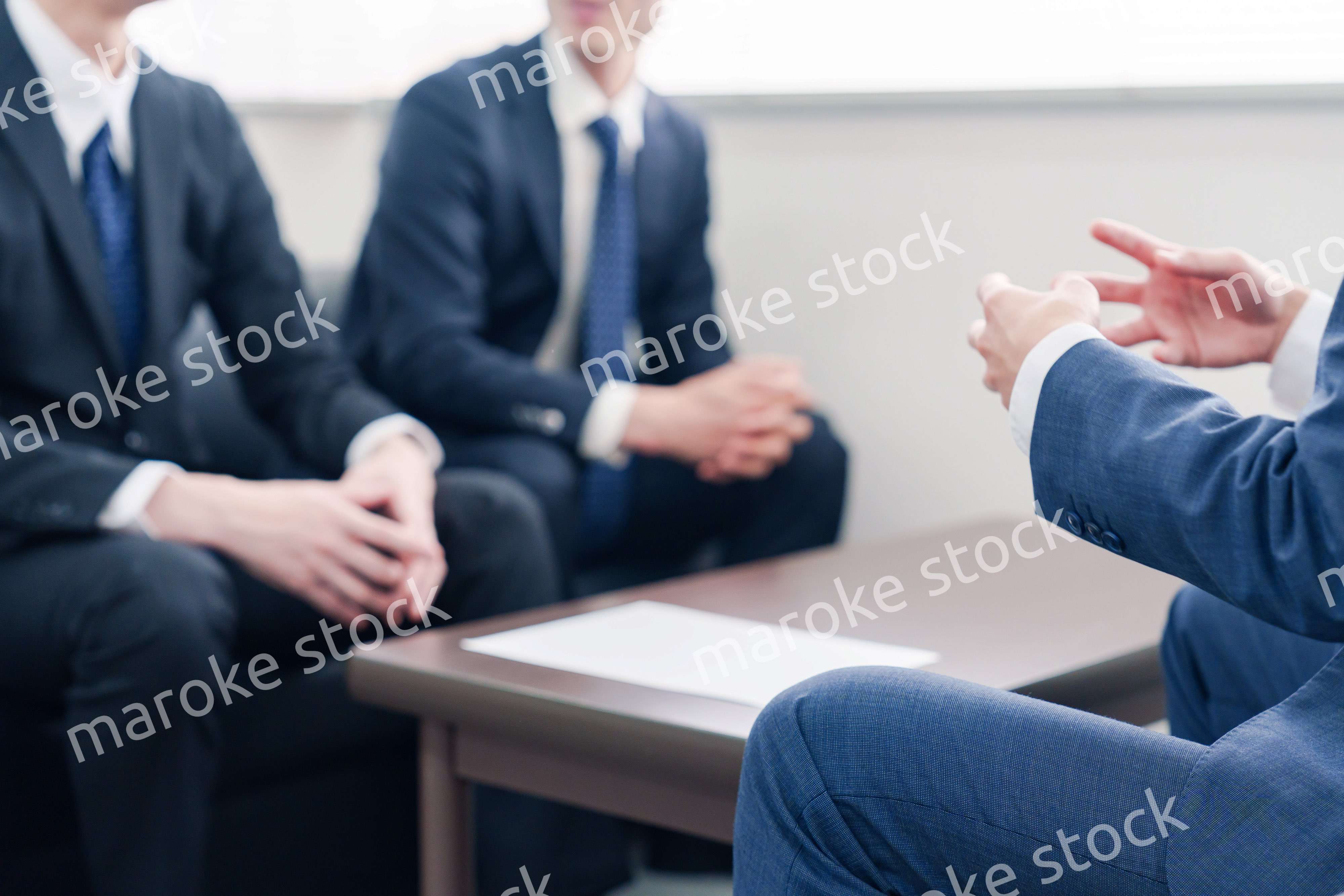 得意先と商談をするスーツを着たビジネスマン