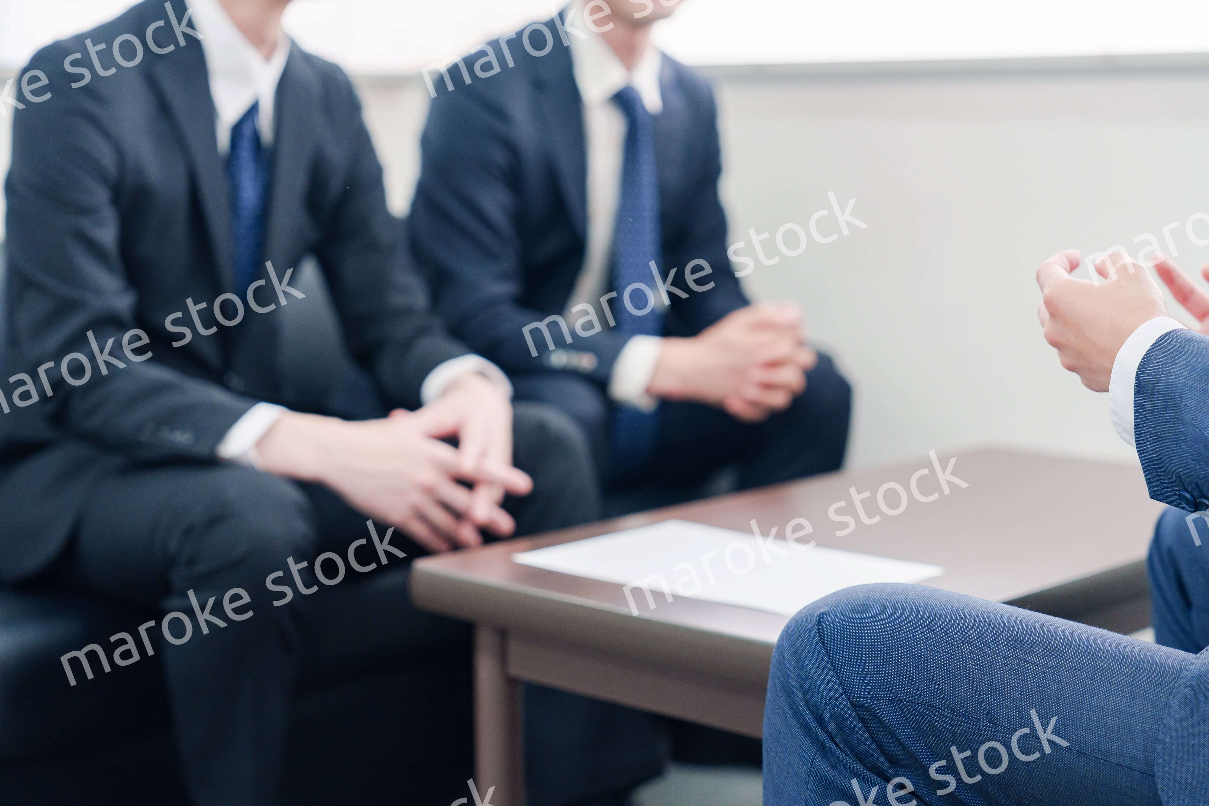 得意先と商談をするスーツを着たビジネスマン