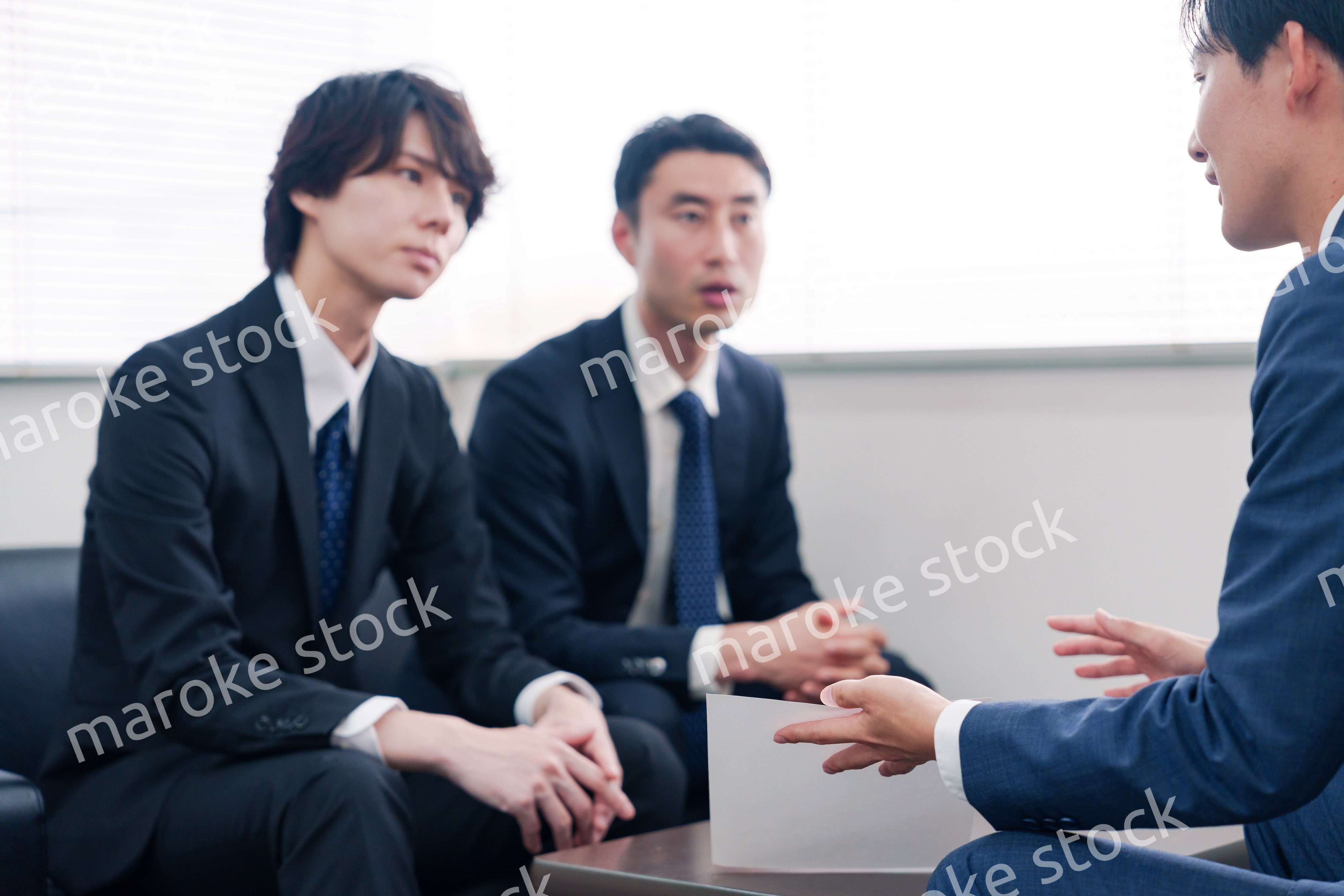 得意先と商談をするスーツを着たビジネスマン