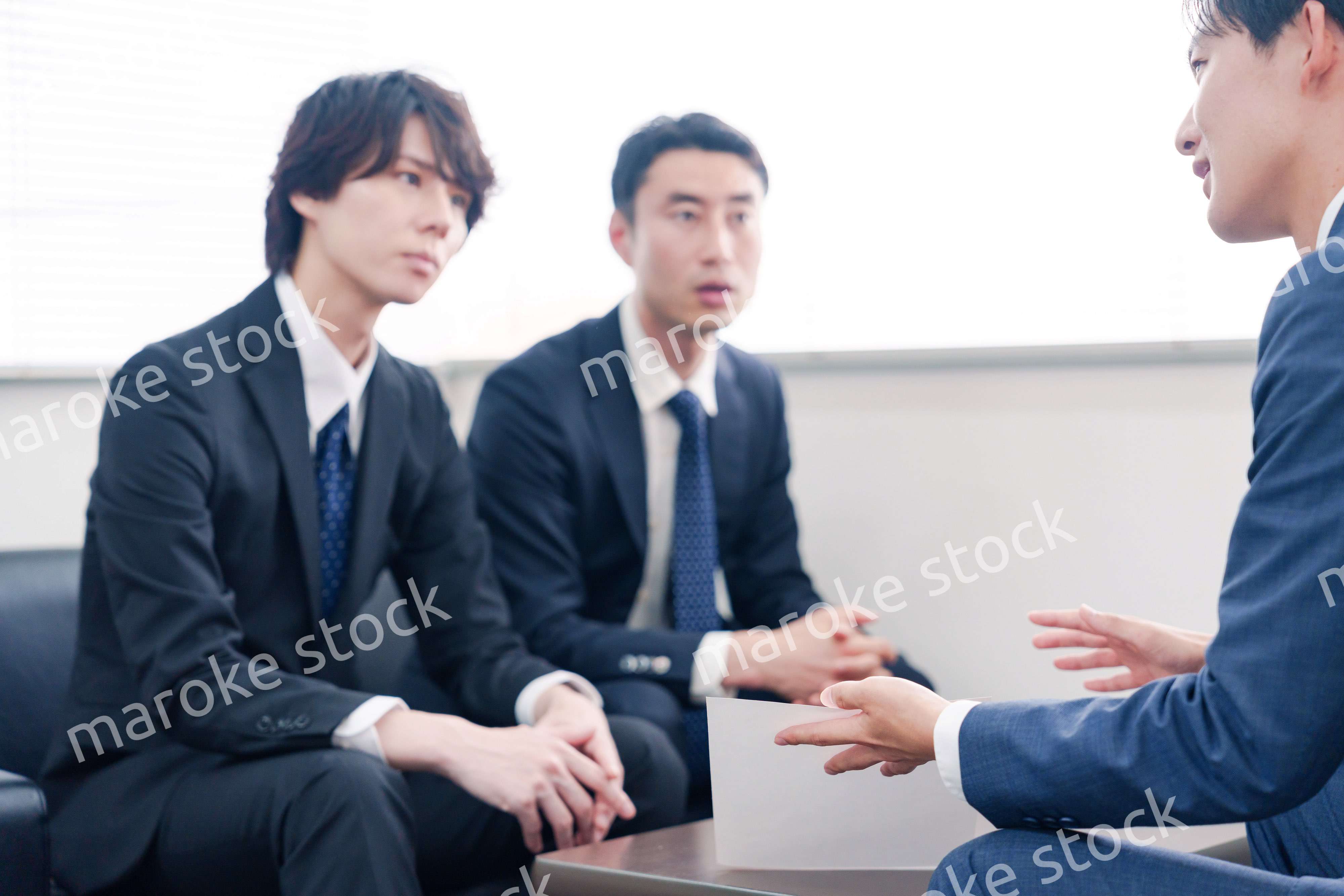 得意先と商談をするスーツを着たビジネスマン