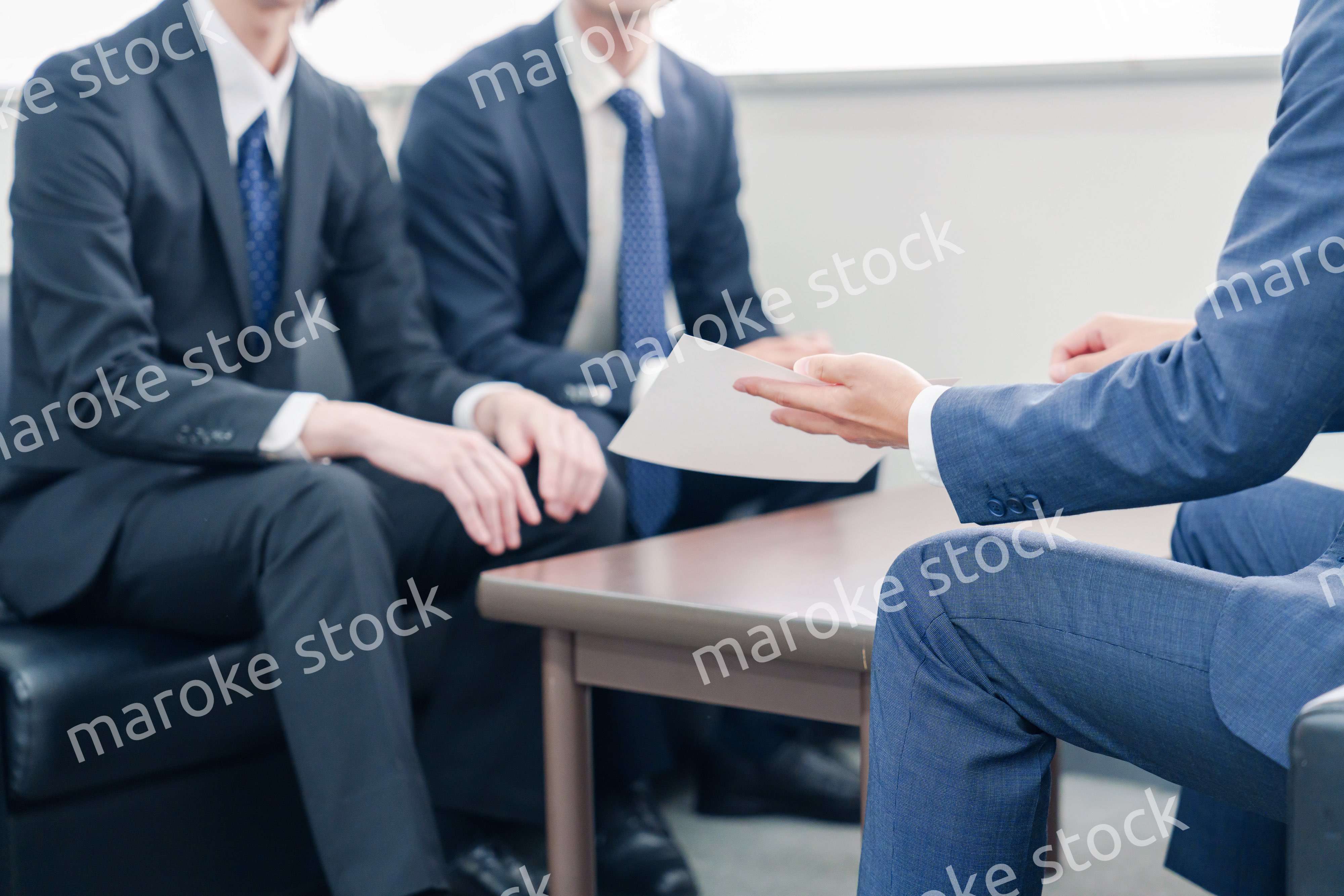 得意先と商談をするスーツを着たビジネスマン