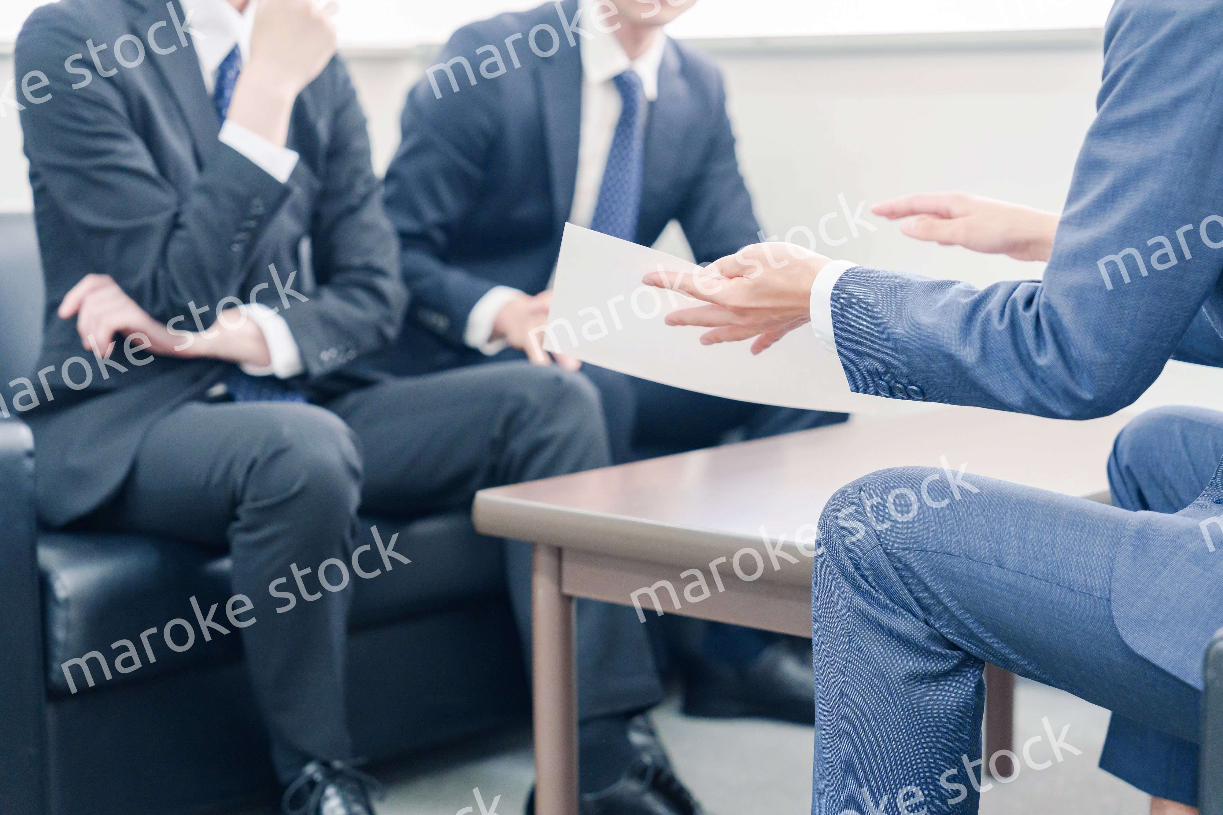 得意先と商談をするスーツを着たビジネスマン