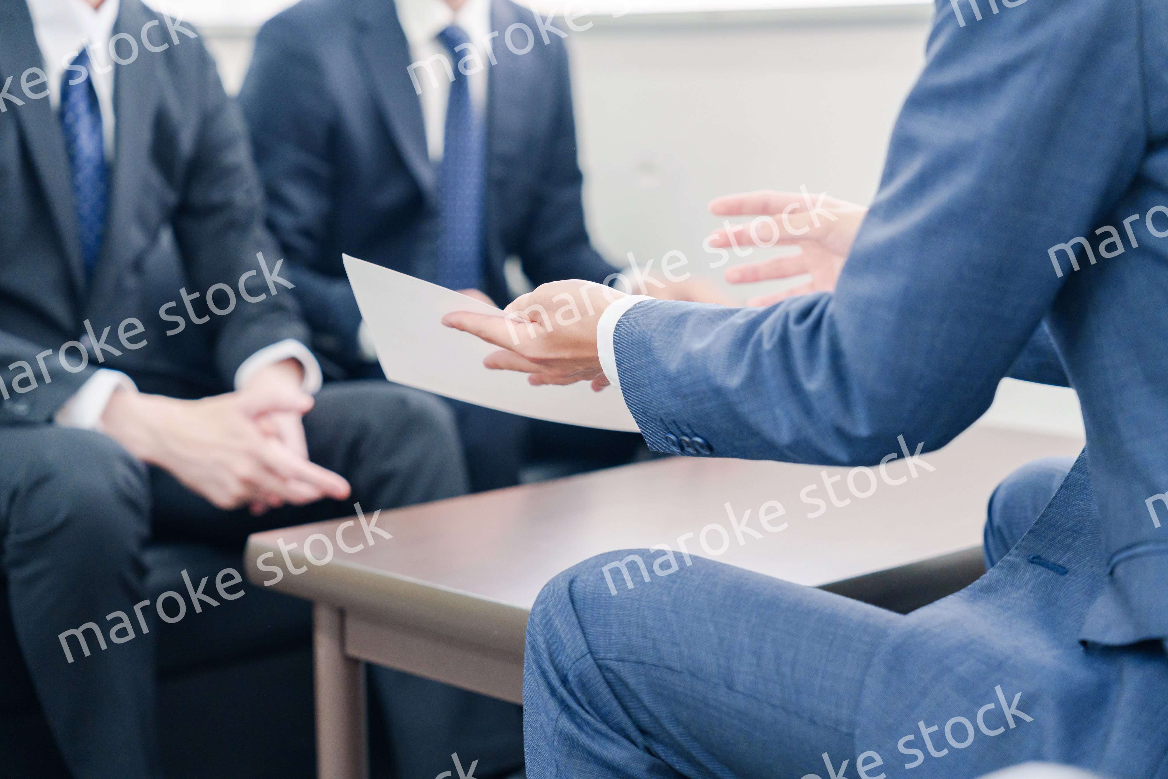 得意先と商談をするスーツを着たビジネスマン