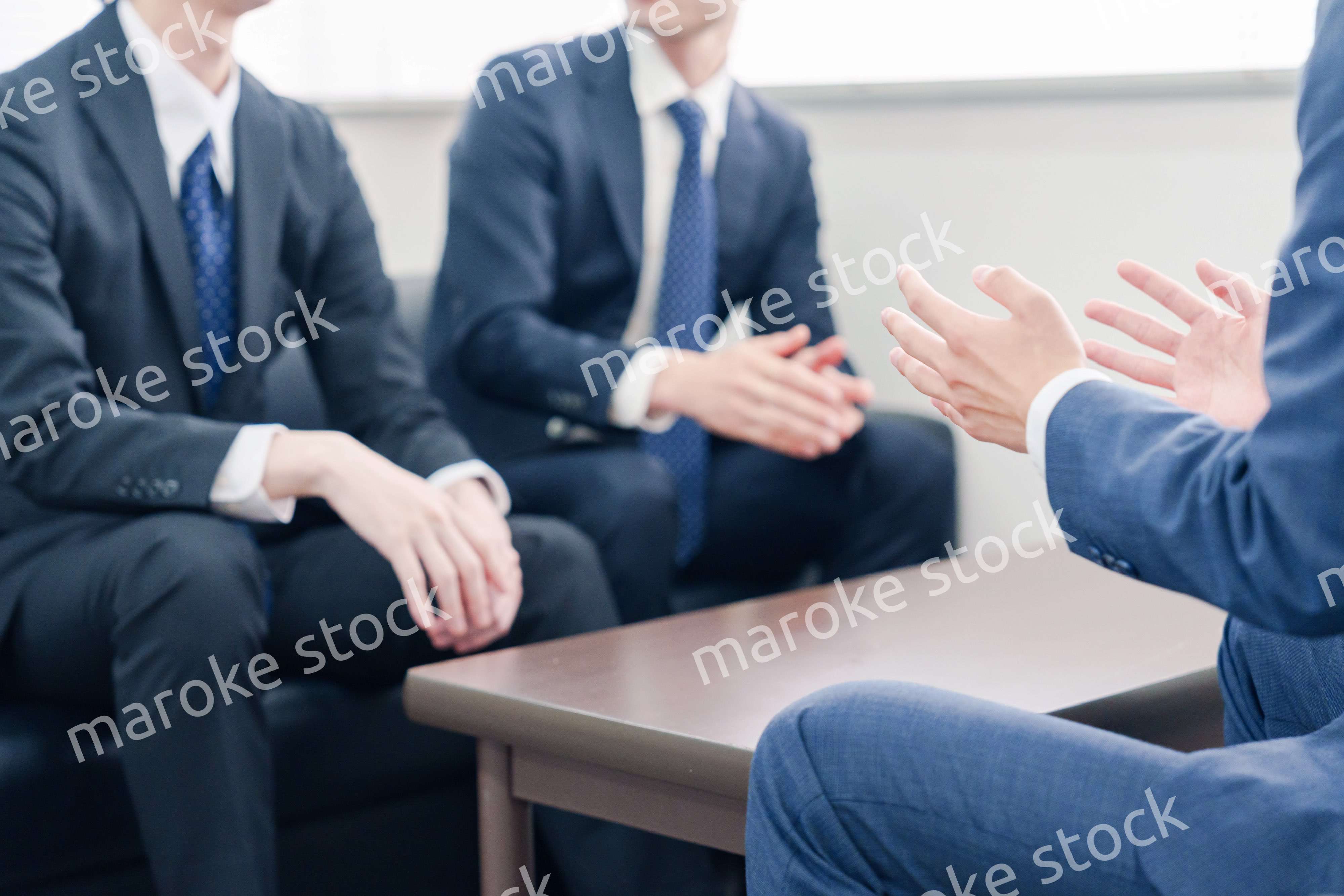 得意先と商談をするスーツを着たビジネスマン