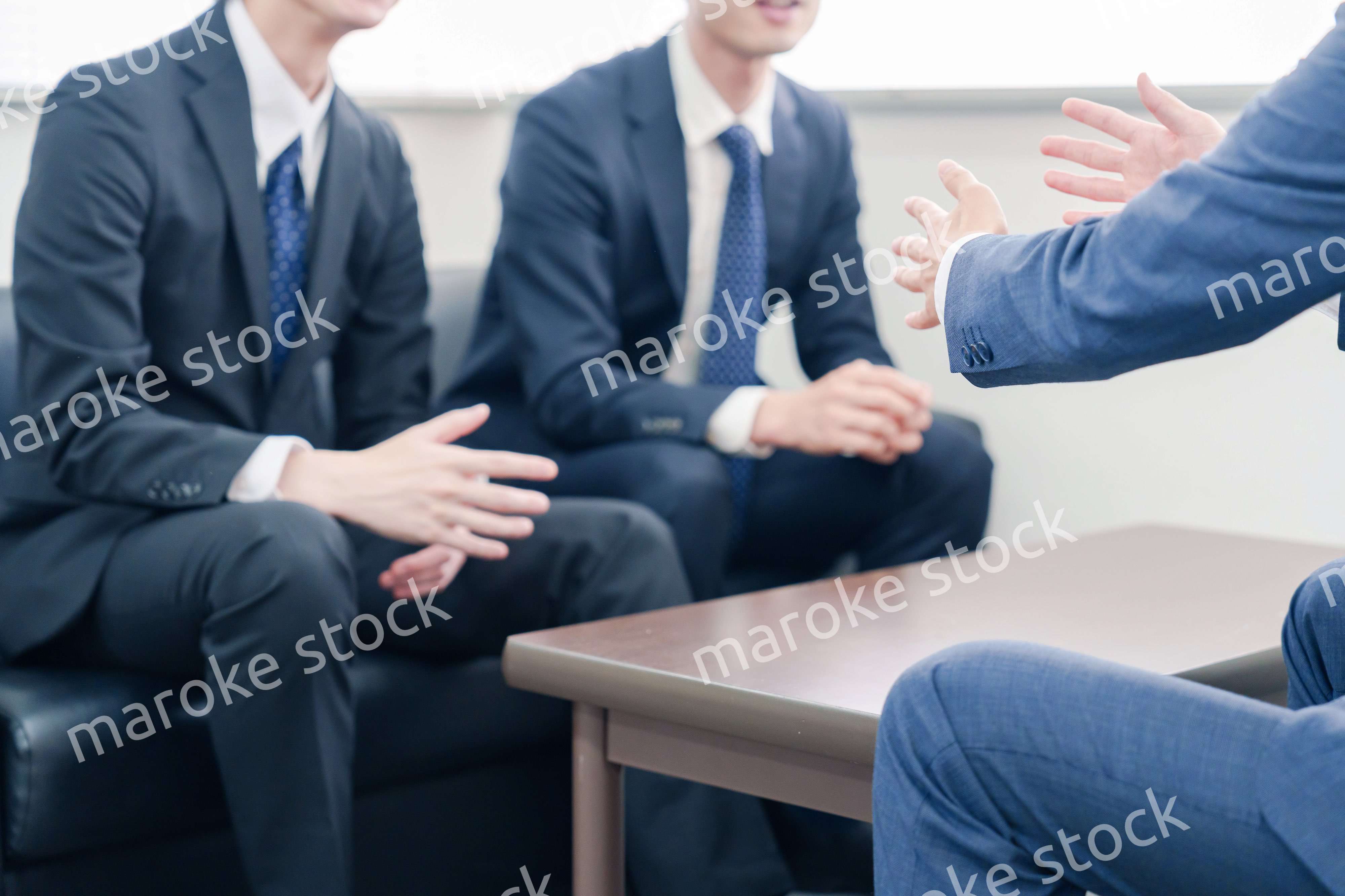 得意先と商談をするスーツを着たビジネスマン