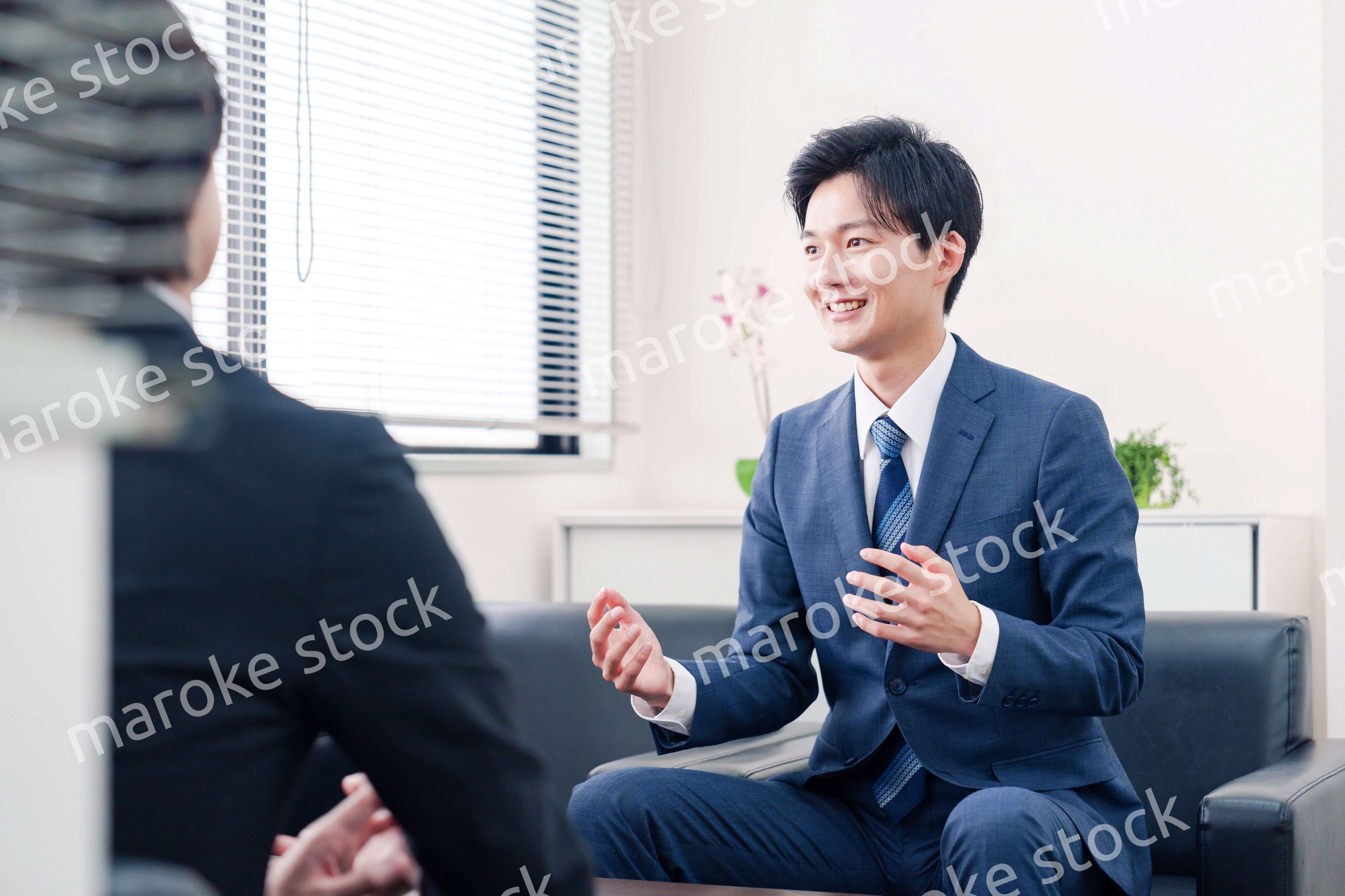 得意先と商談をするスーツを着たビジネスマン