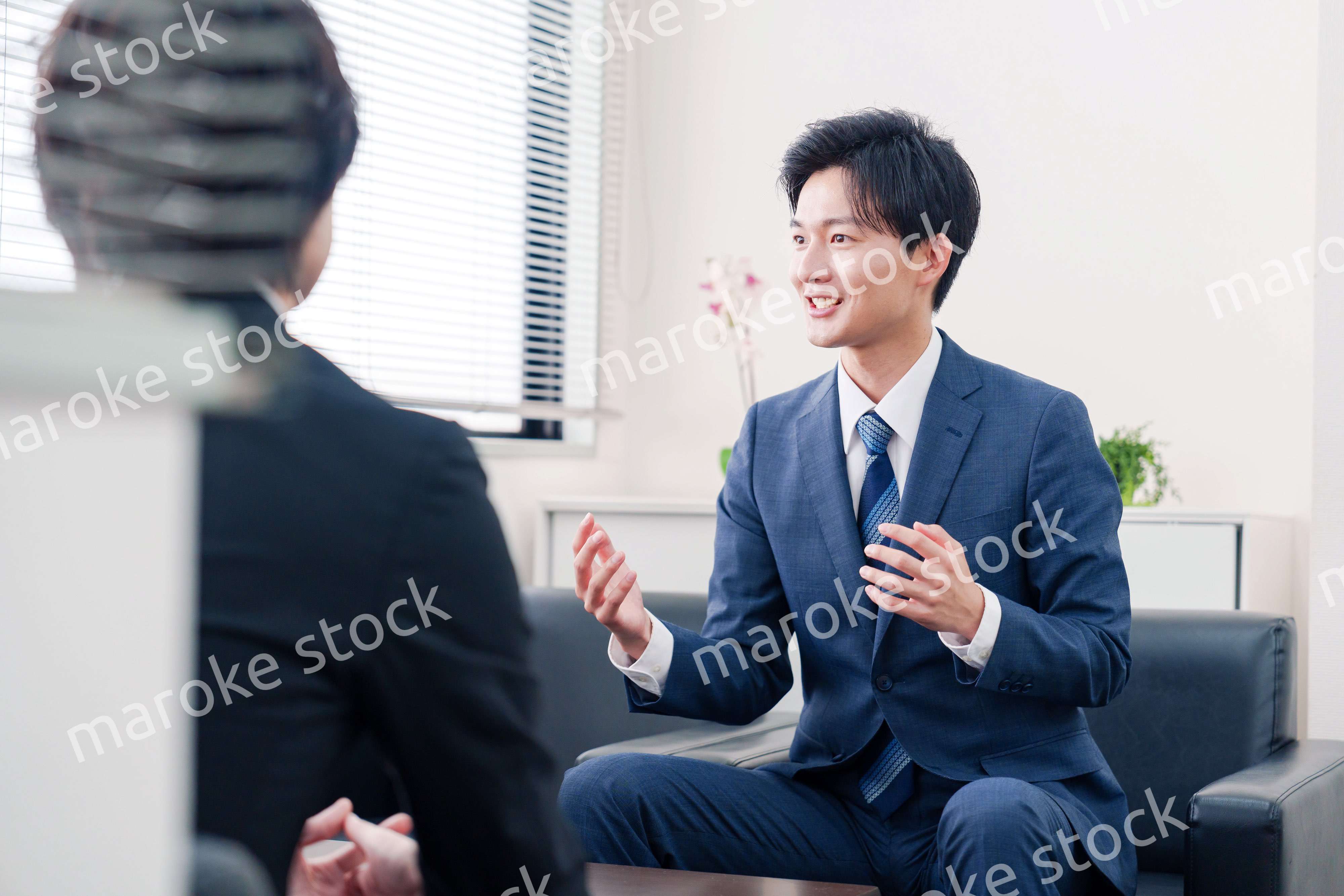 得意先と商談をするスーツを着たビジネスマン