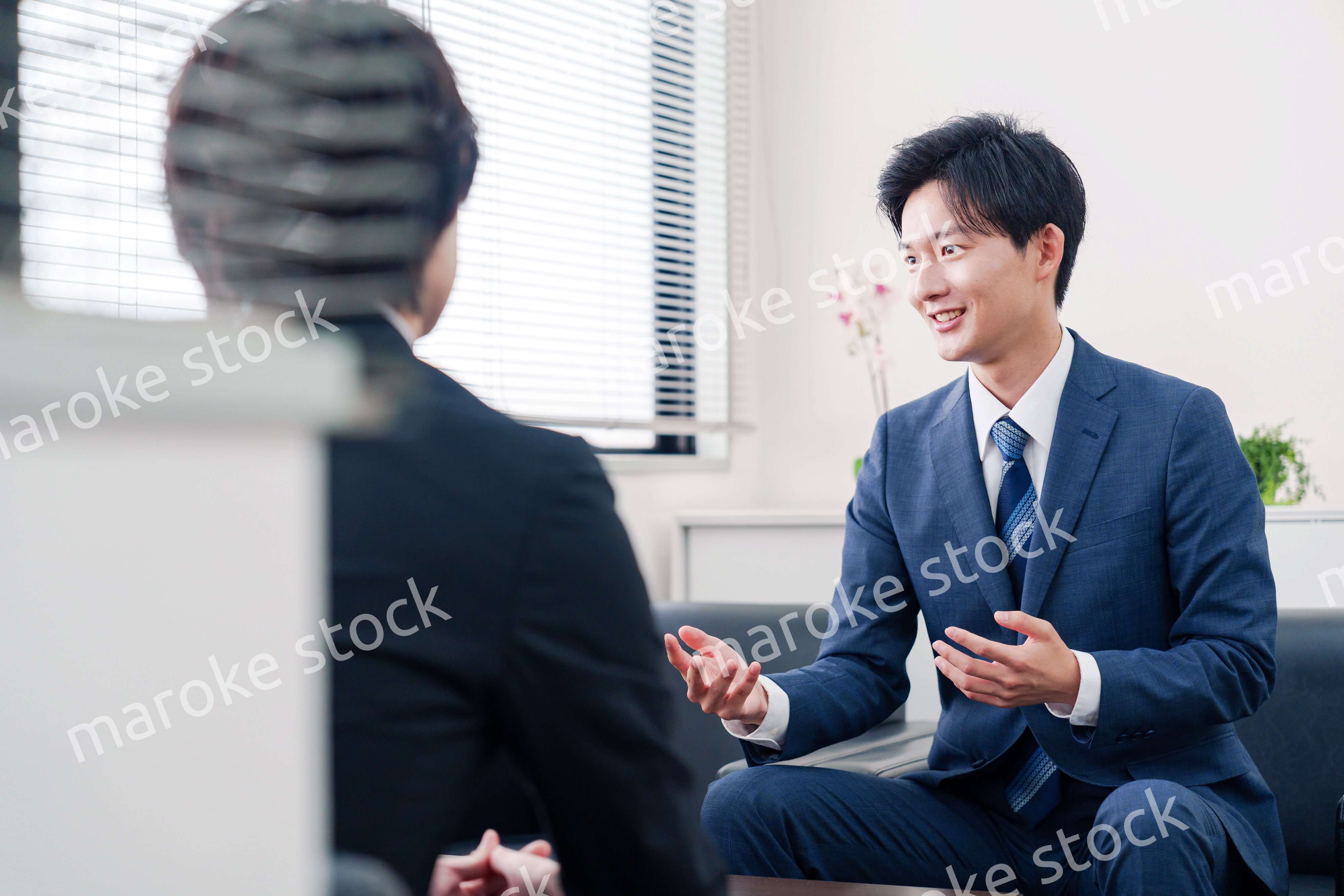 得意先と商談をするスーツを着たビジネスマン