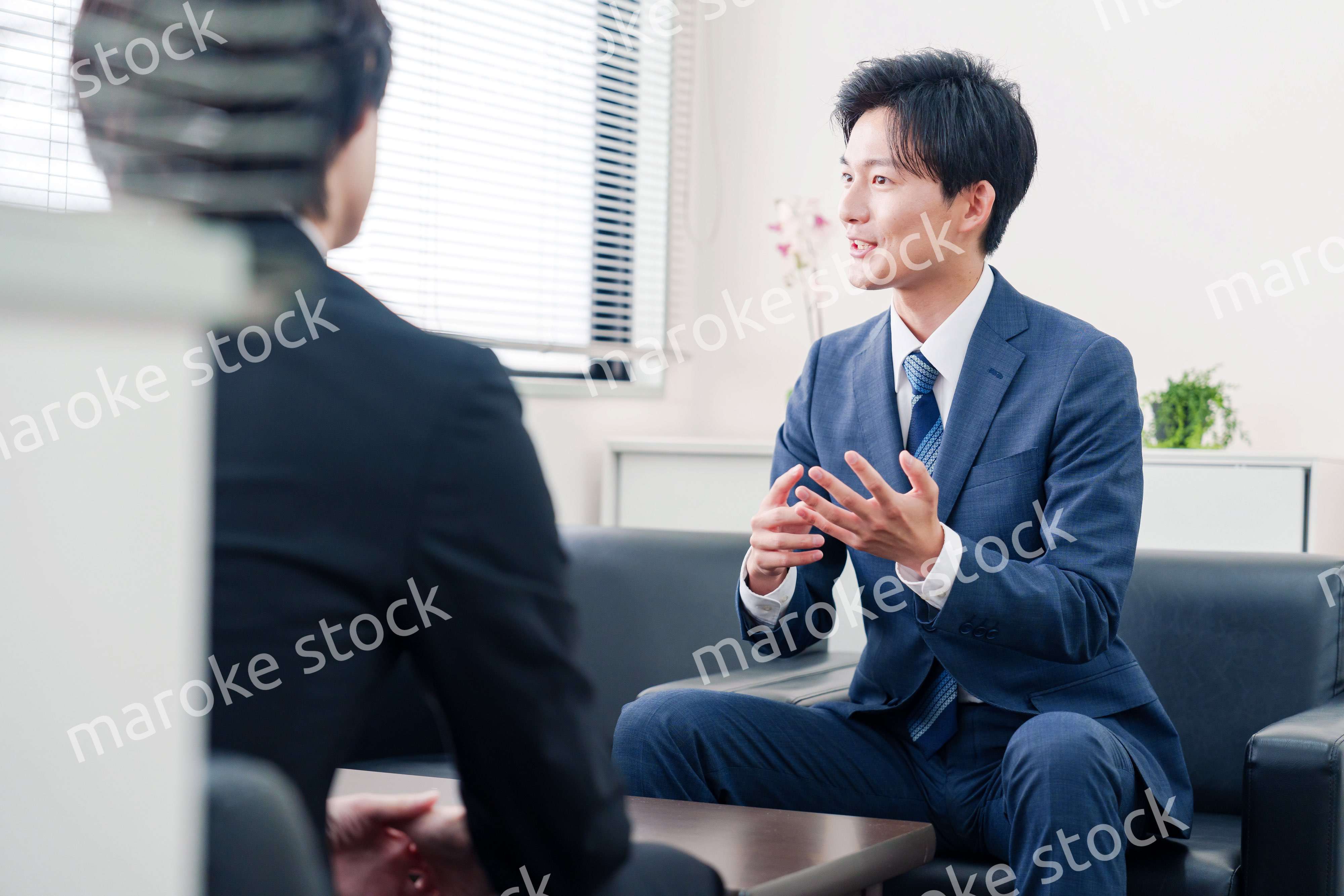 得意先と商談をするスーツを着たビジネスマン