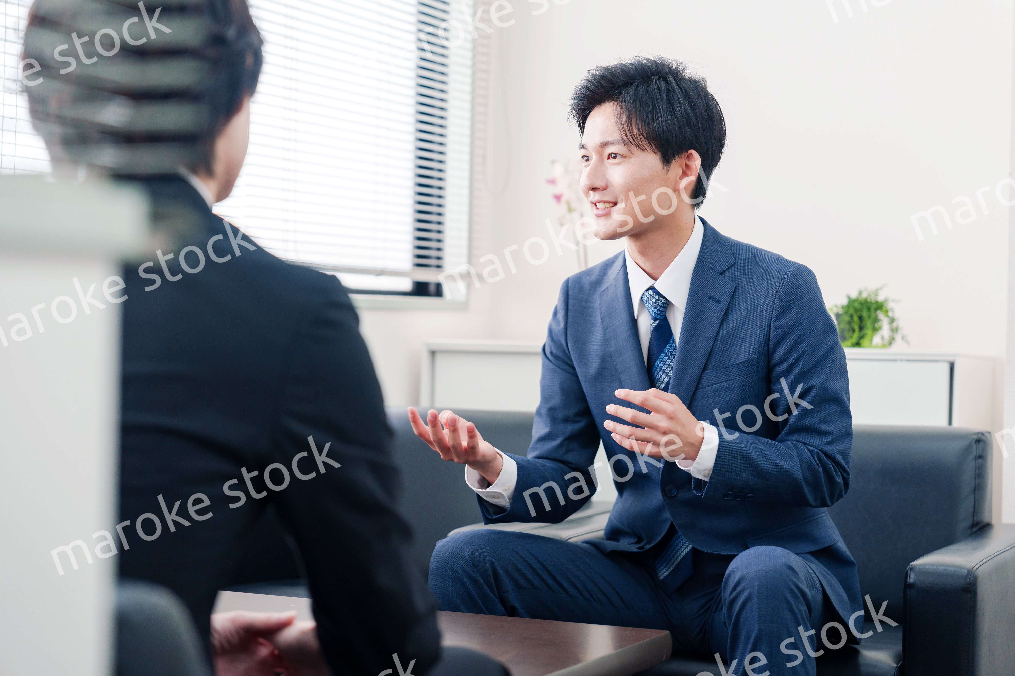 得意先と商談をするスーツを着たビジネスマン