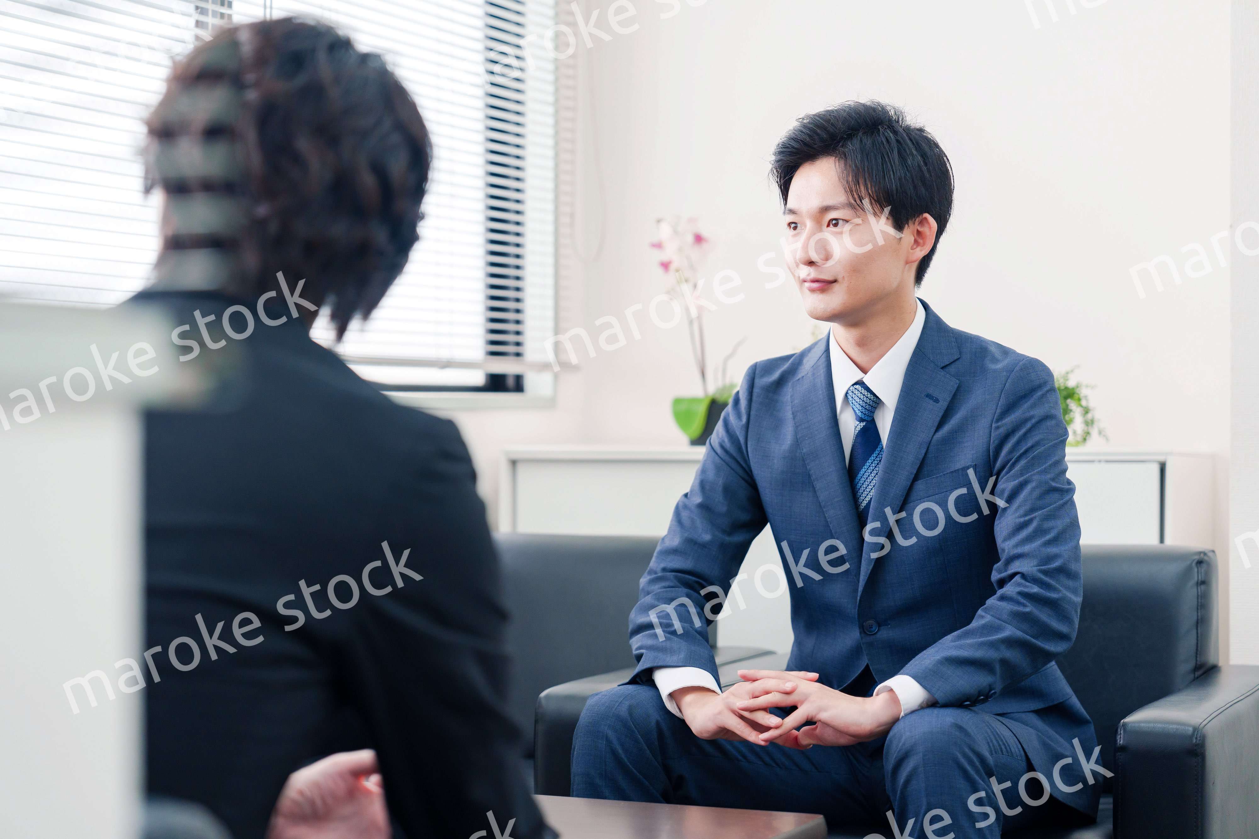 得意先と商談をするスーツを着たビジネスマン