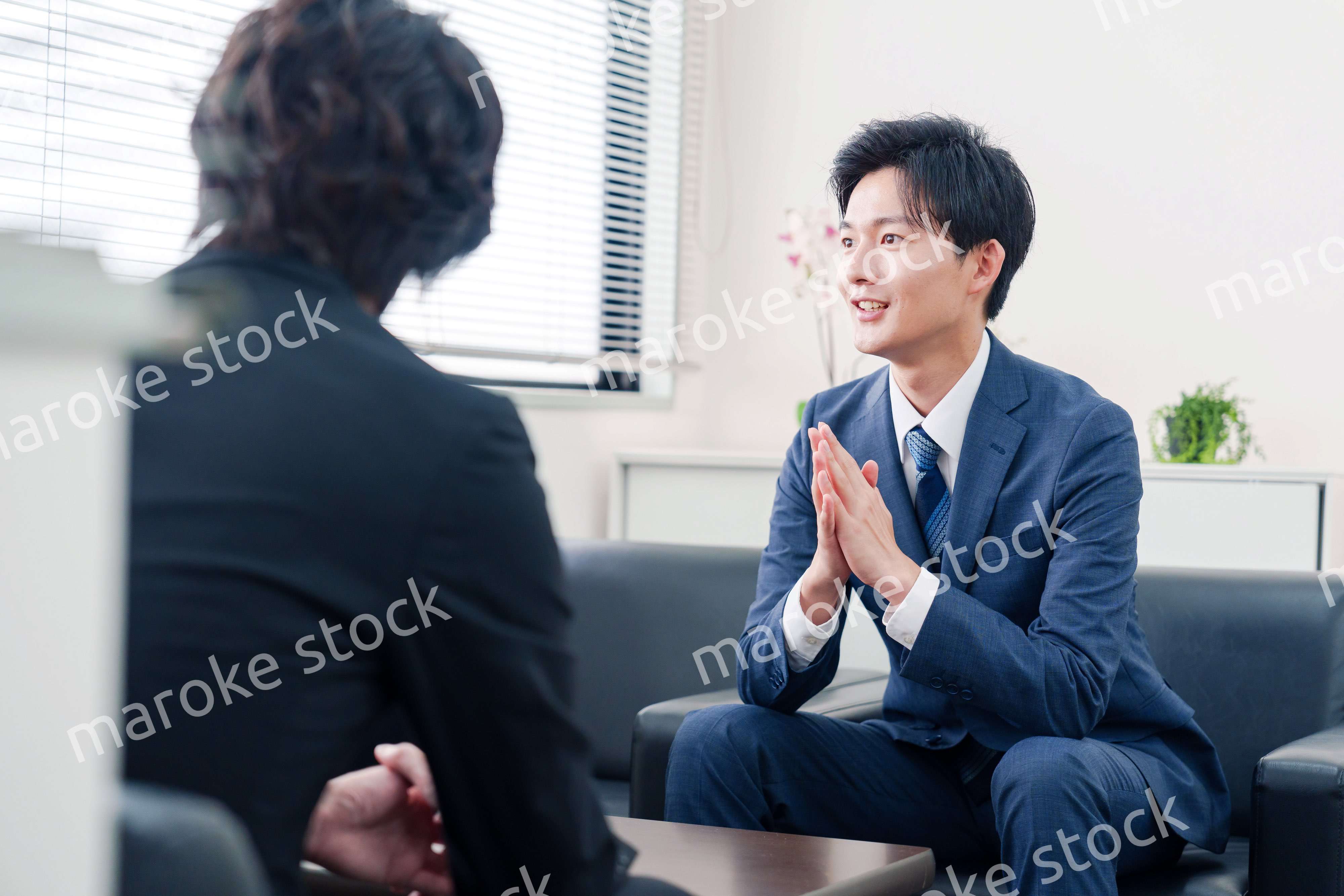 得意先と商談をするスーツを着たビジネスマン