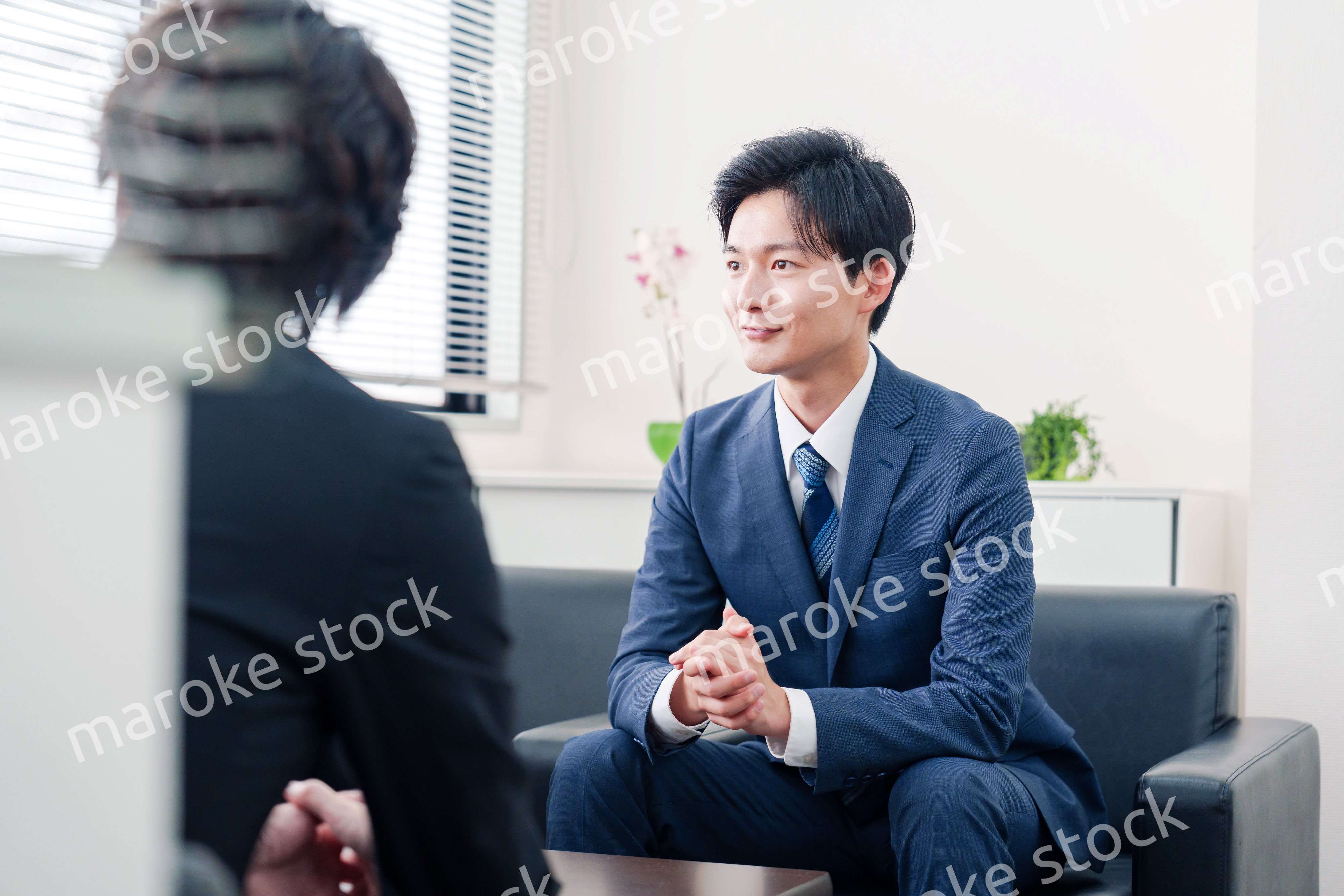 得意先と商談をするスーツを着たビジネスマン