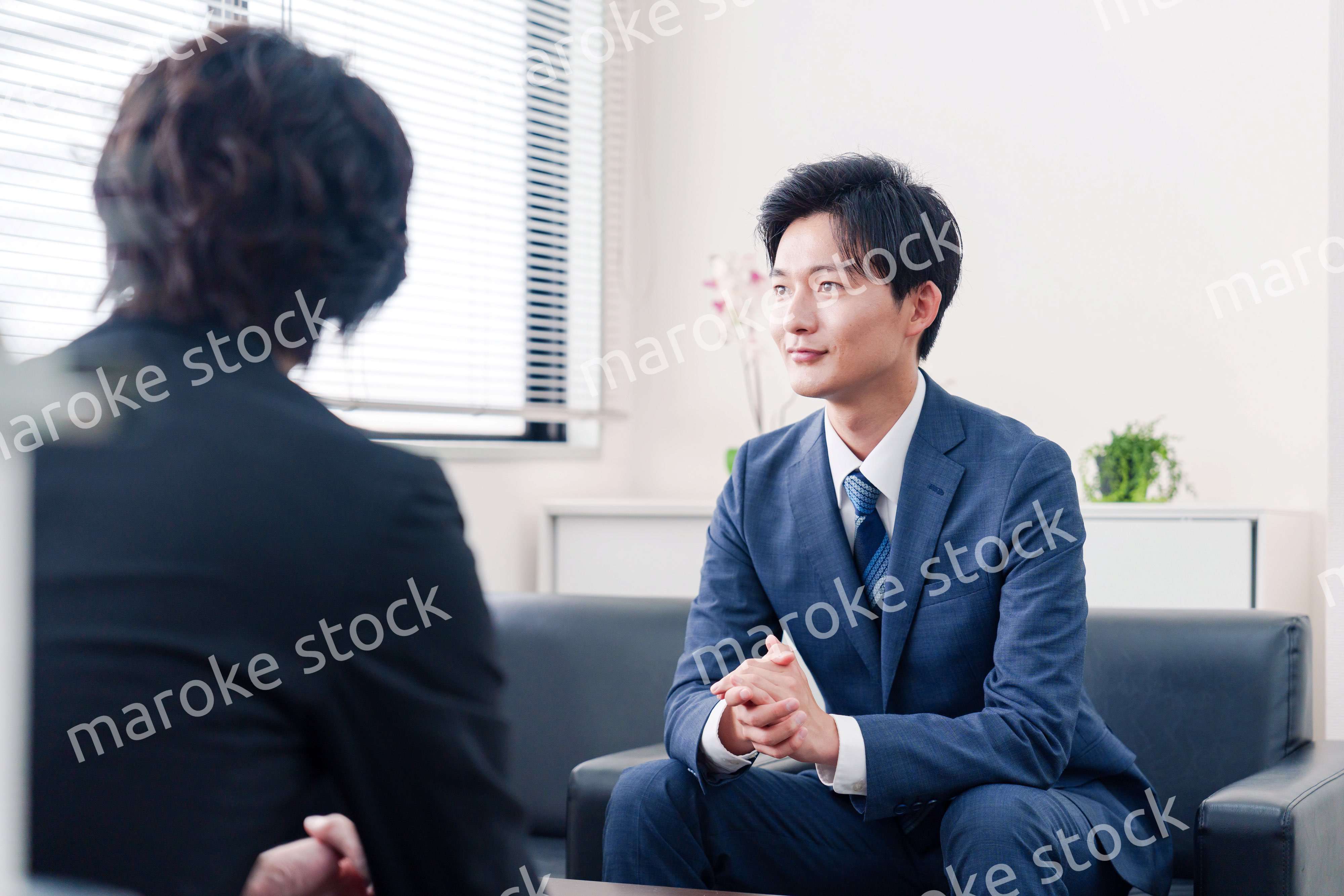 得意先と商談をするスーツを着たビジネスマン