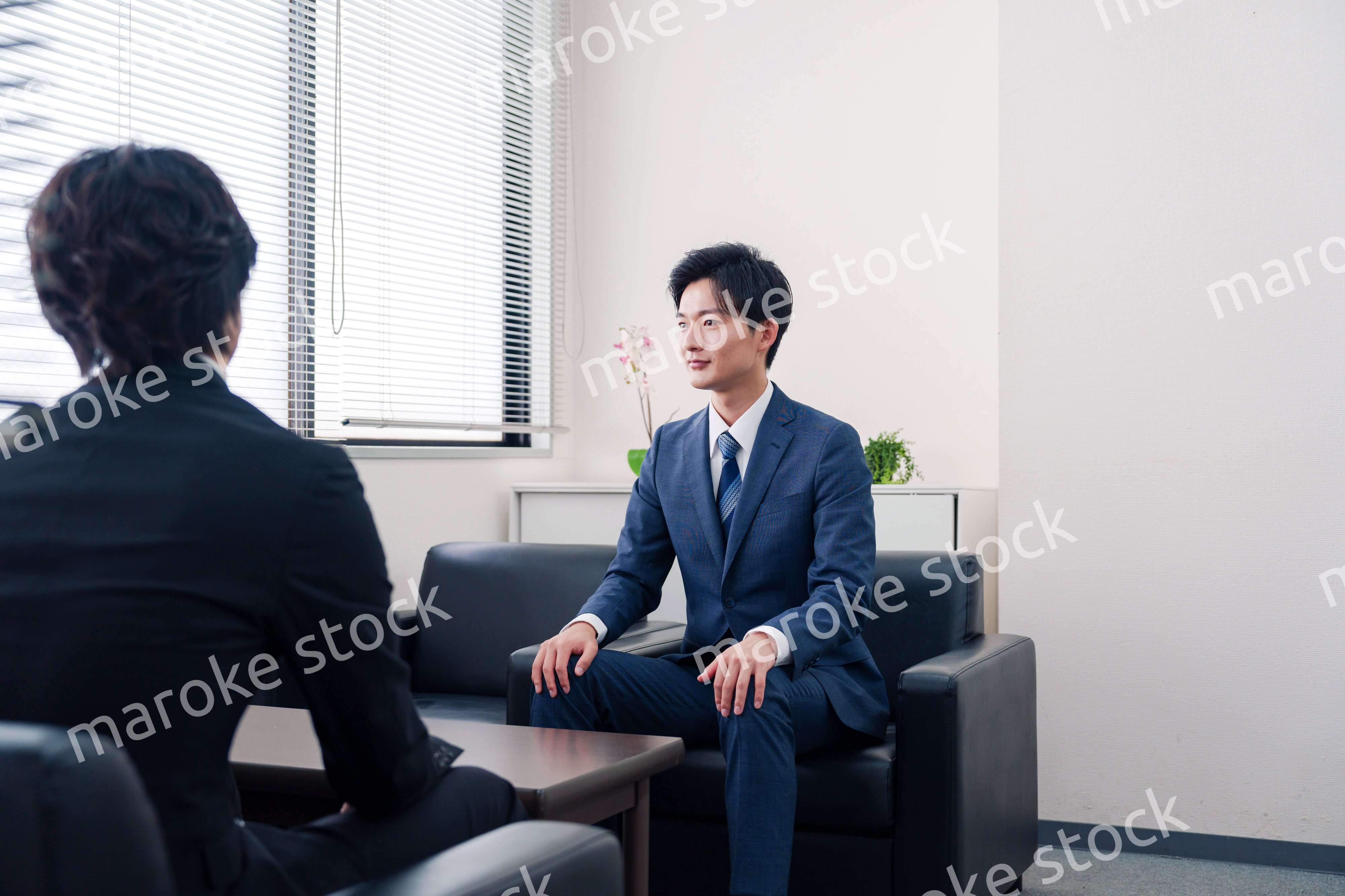 得意先と商談をするスーツを着たビジネスマン