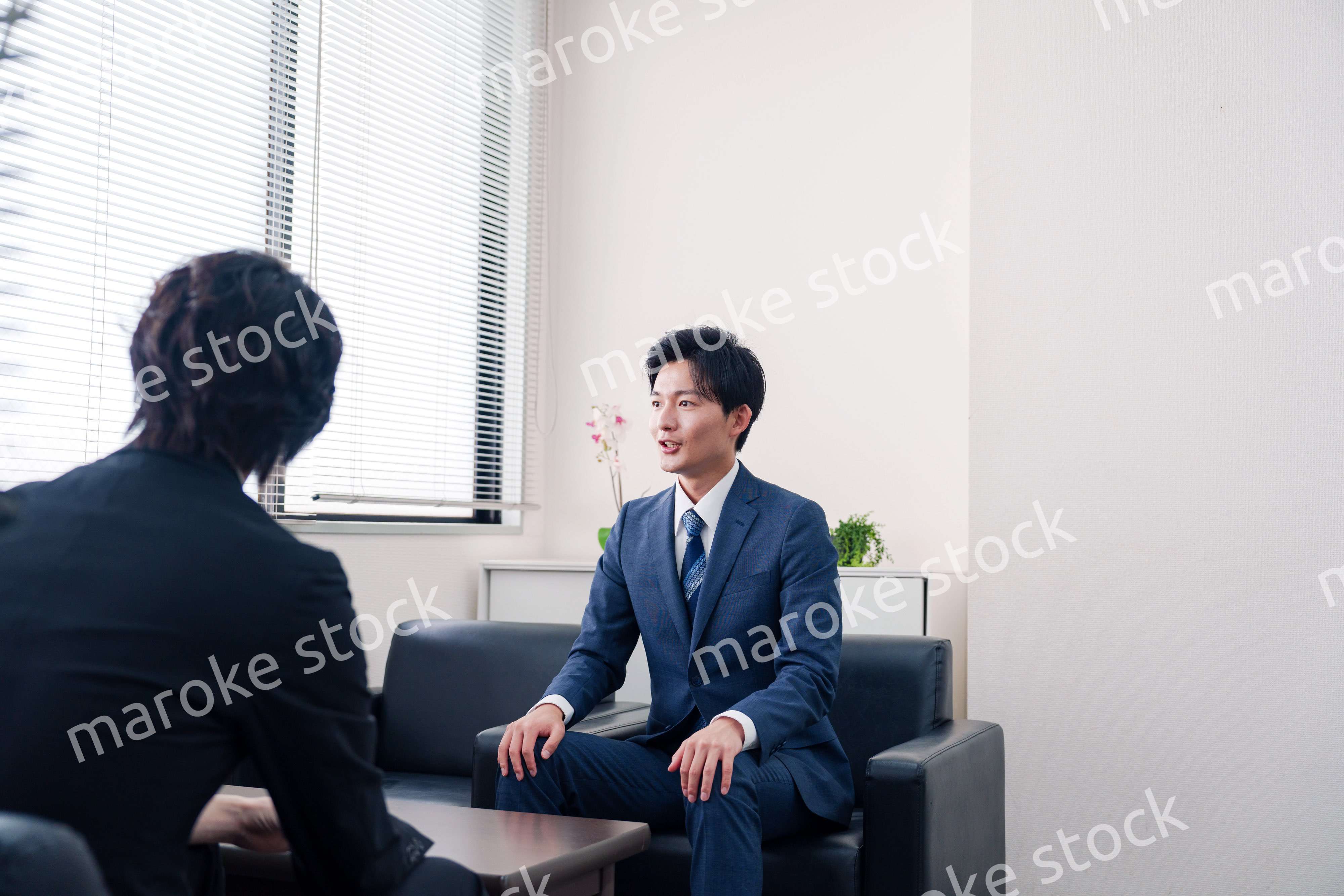 得意先と商談をするスーツを着たビジネスマン