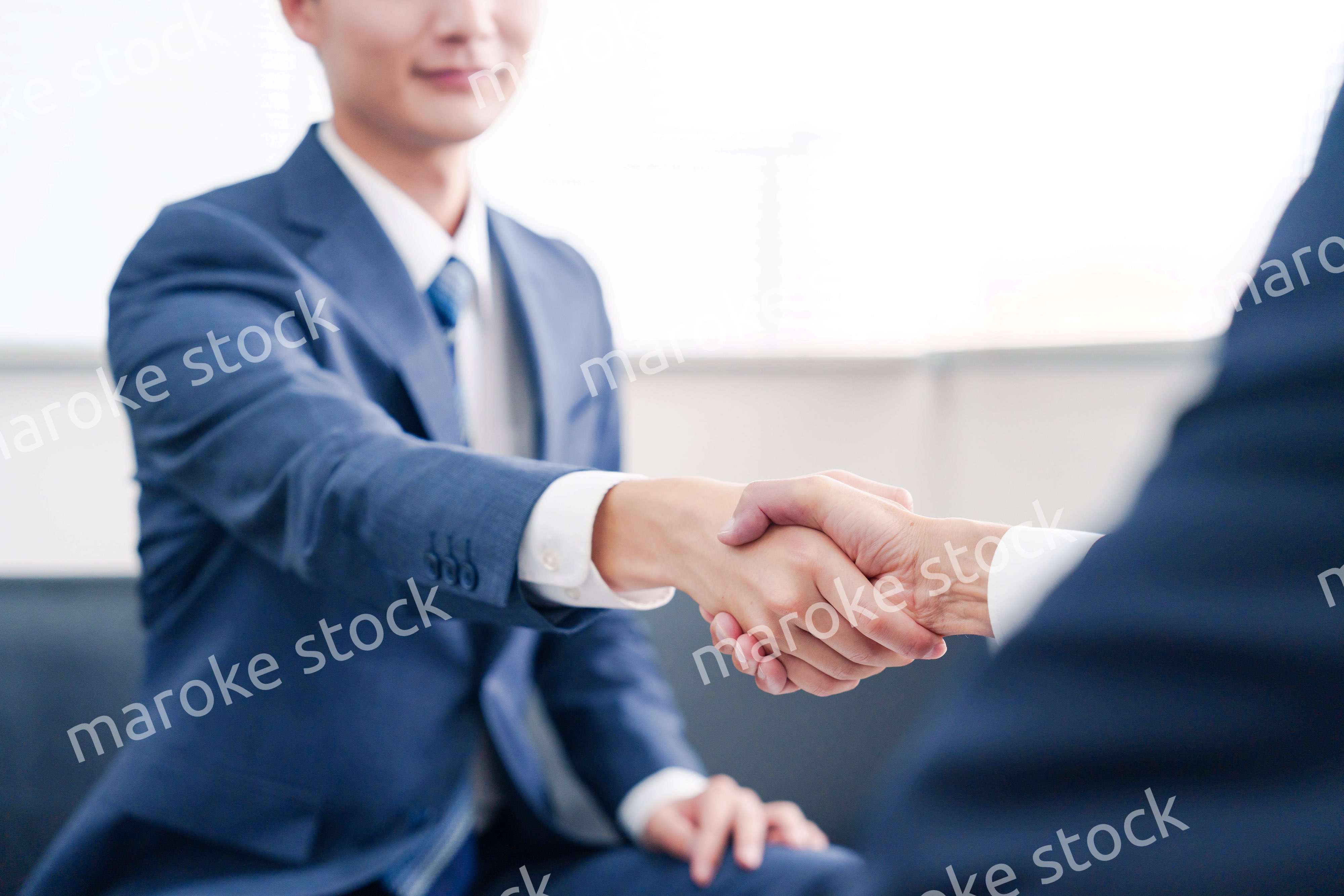 得意先と握手をするビジネスマン